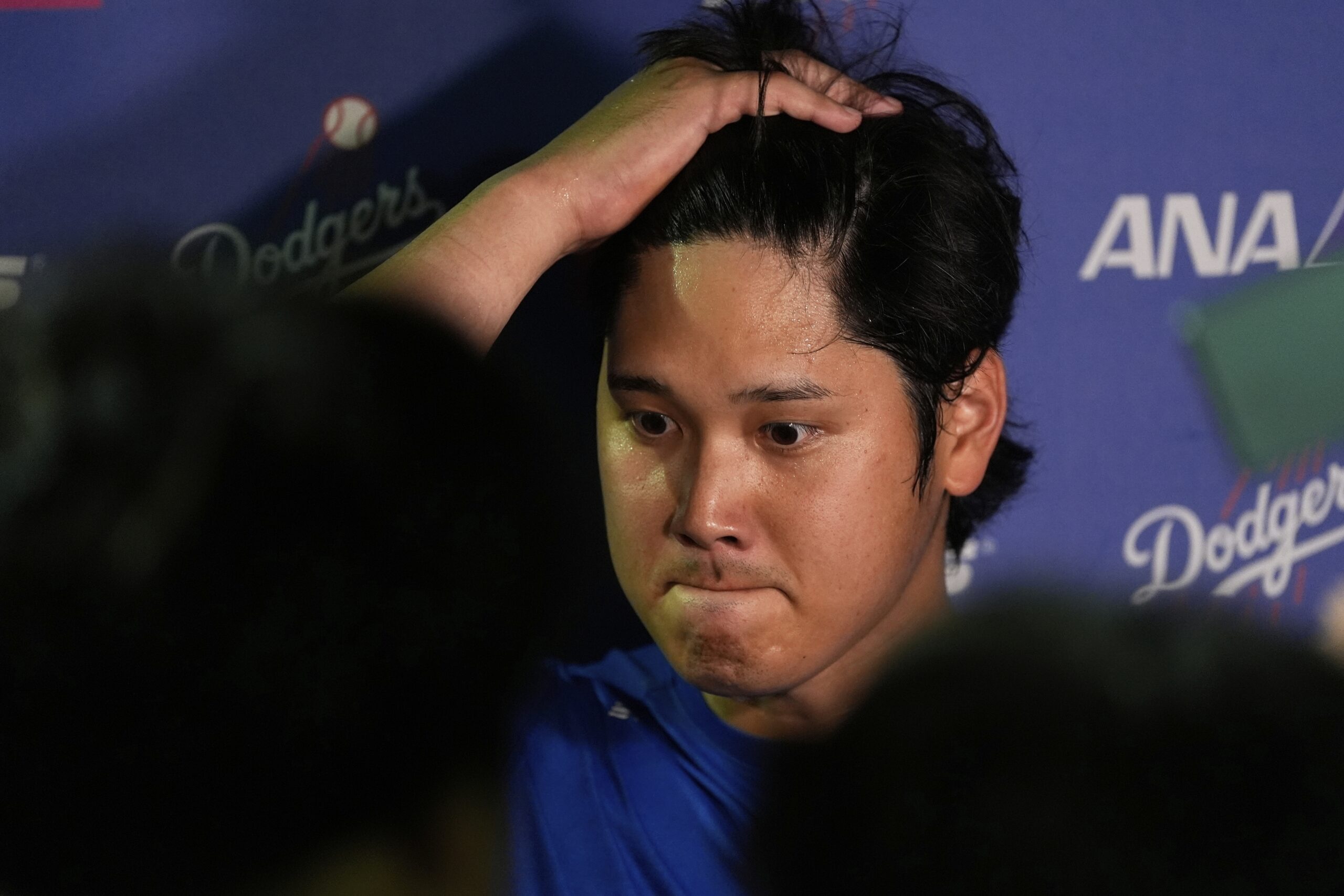 Dodgers star Shohei Ohtani talks to reporters after a game...