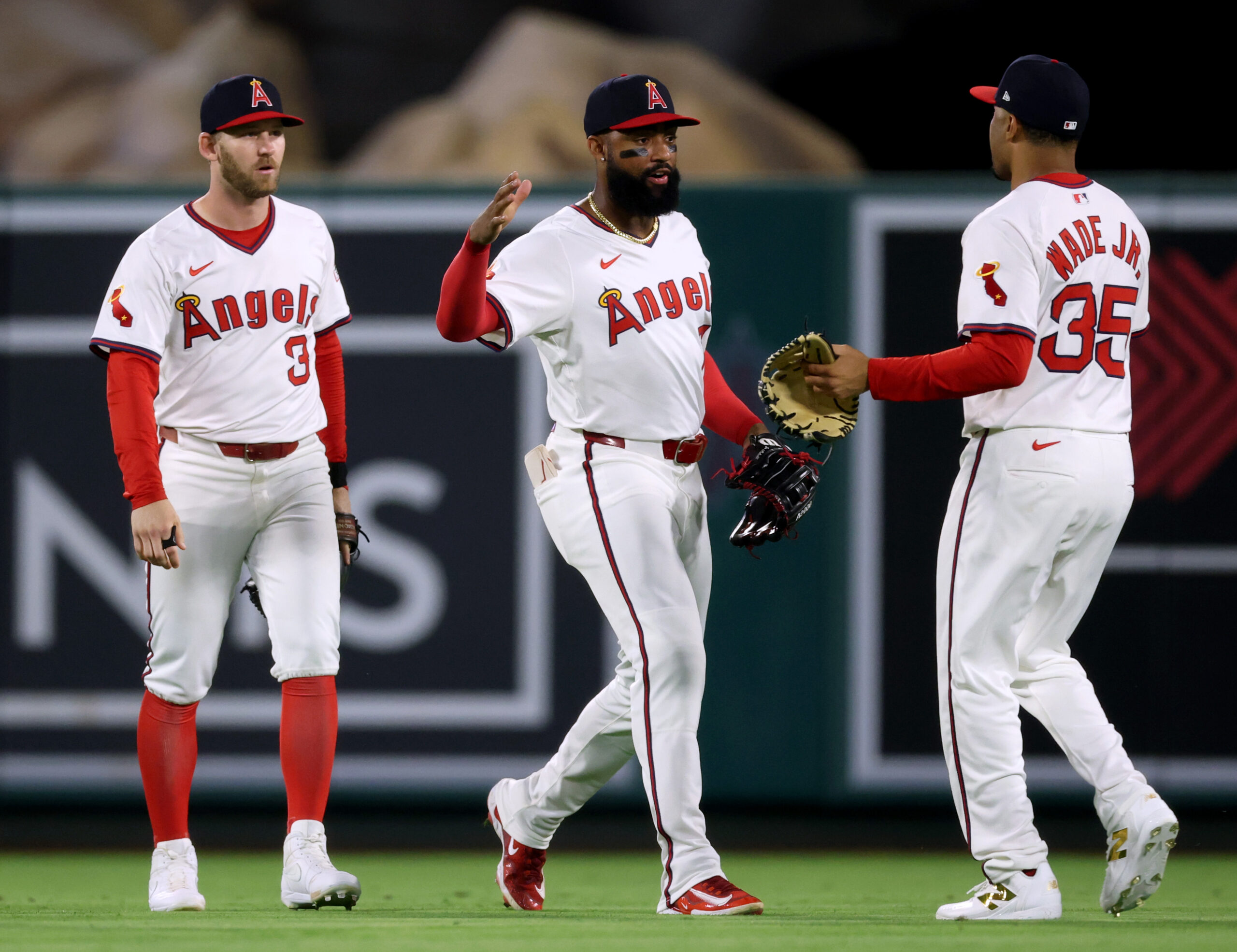 Angels outfielders Jo Adell, center, Taylor Ward, left, and LaMonte...