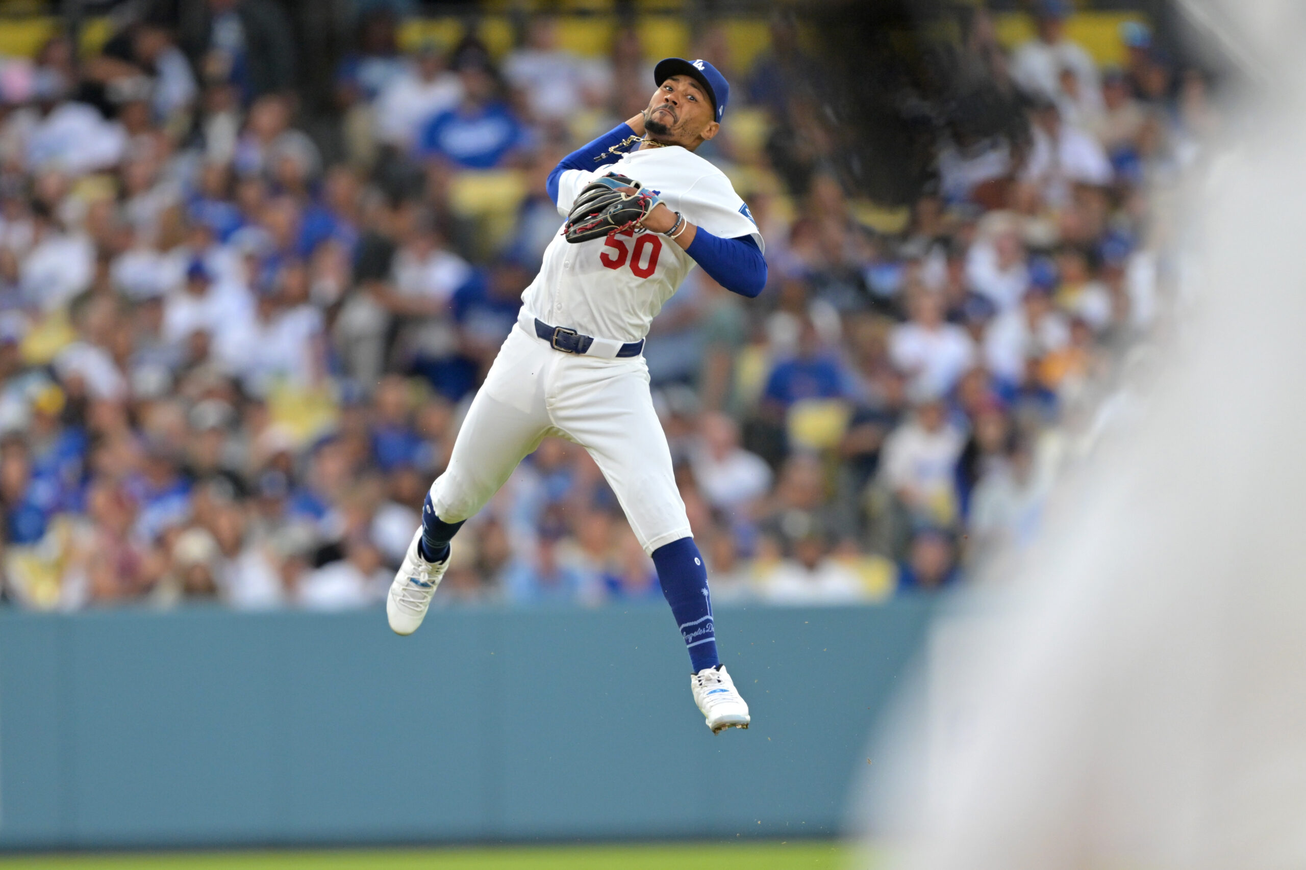 Dodgers shortstop Mookie Betts makes a leaping throw but is...