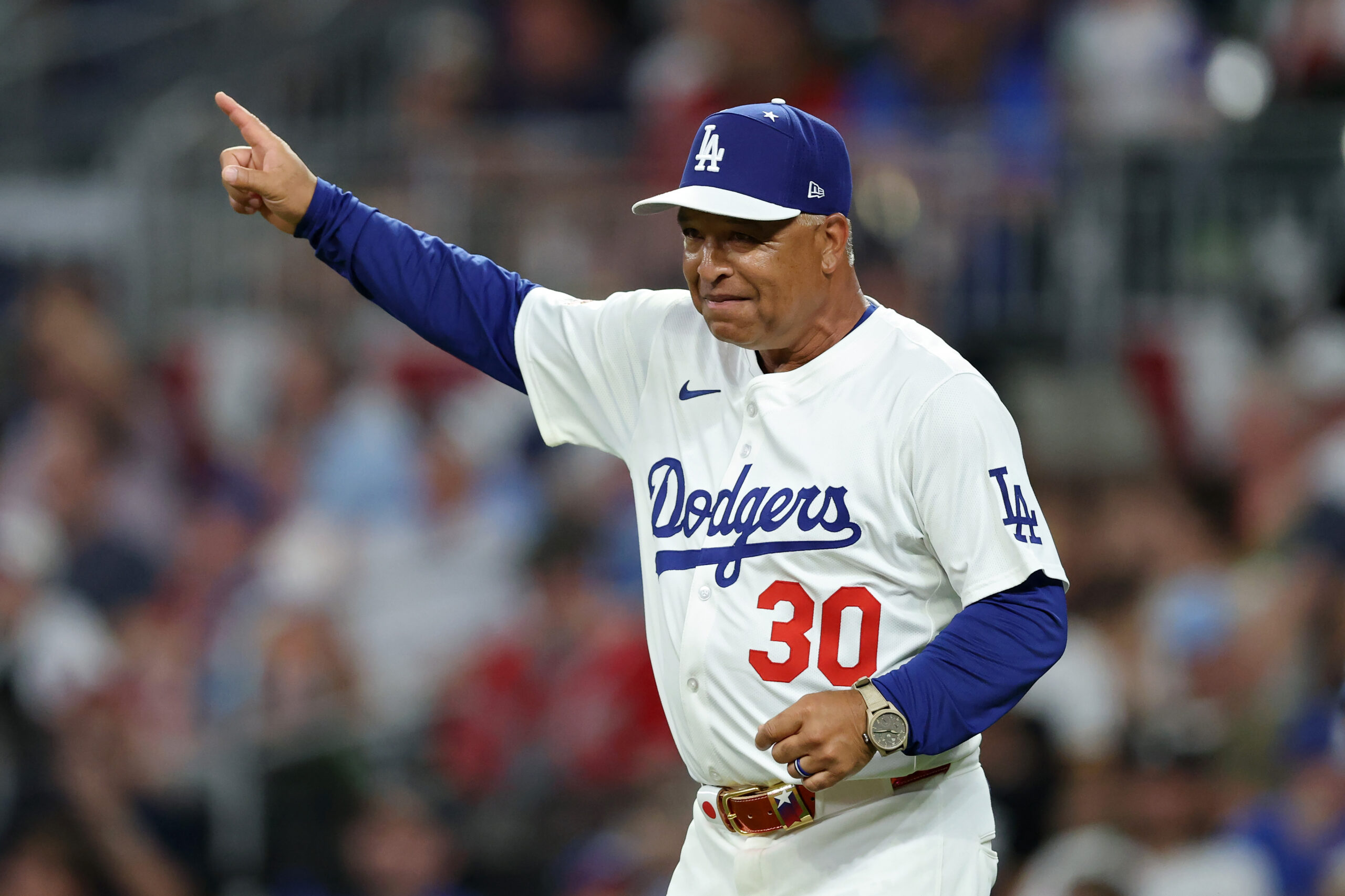 Dodgers manager Dave Roberts signals to the bullpen to make...