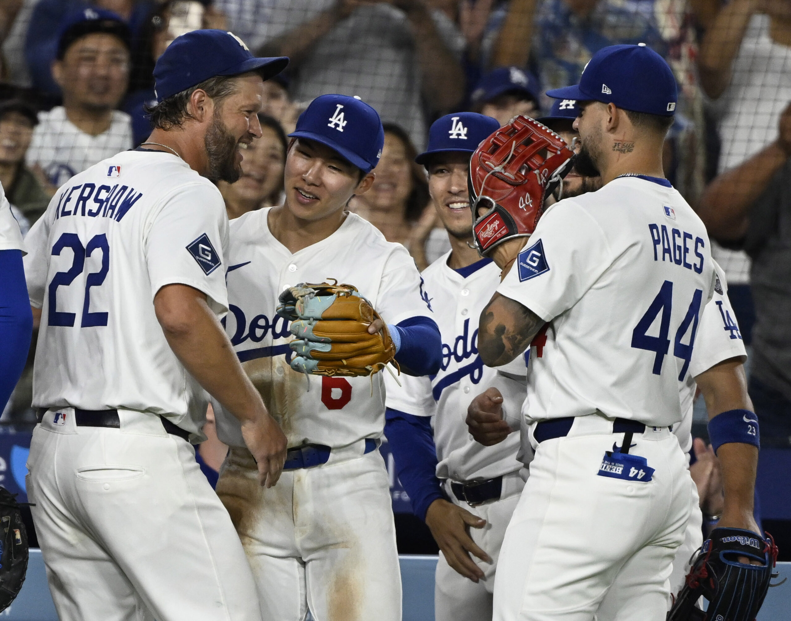 Dodgers starting pitcher Clayton Kershaw celebrates with teammates after recording...