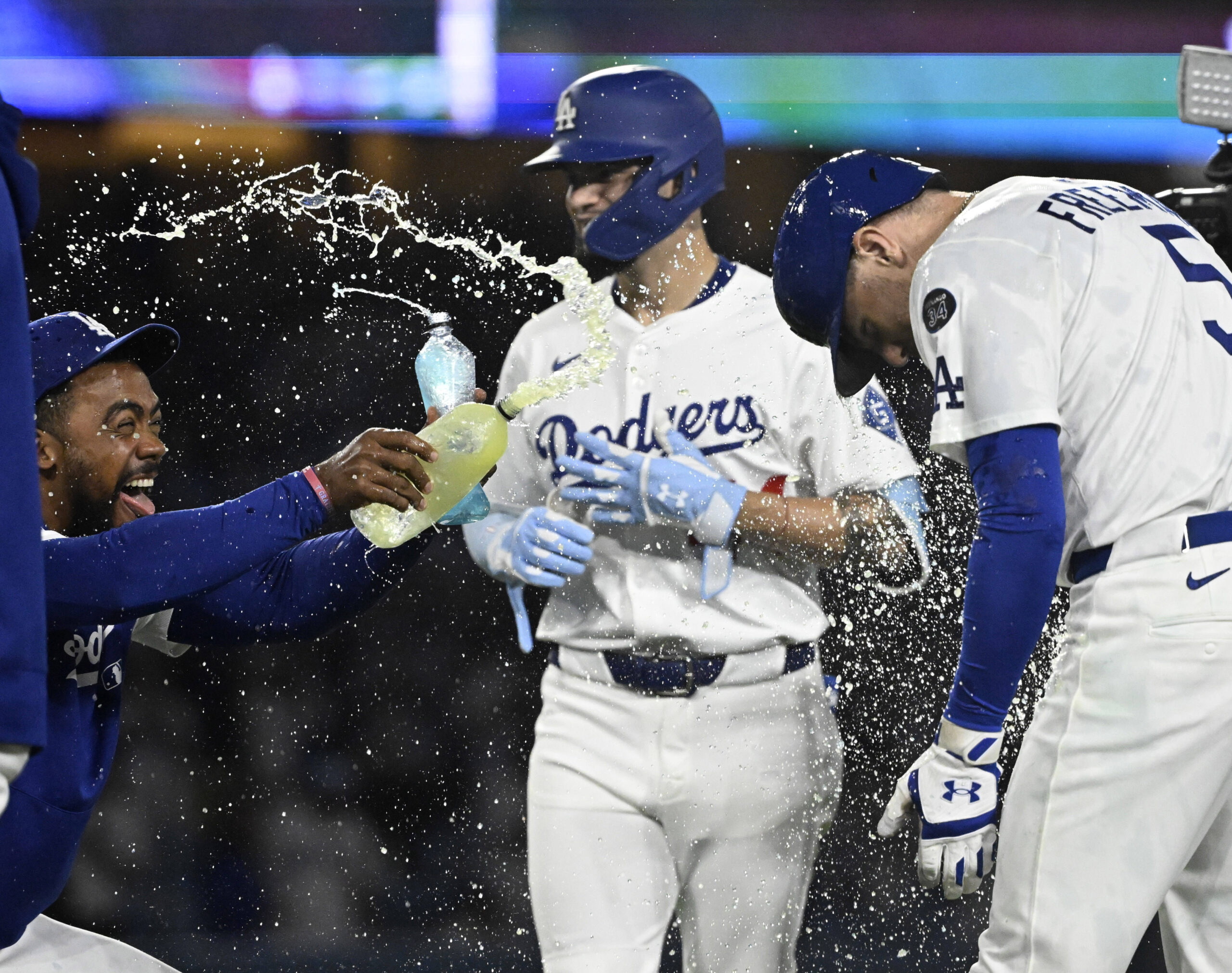Teoscar Hernández, left, douses Freddie Freeman #5 of the Los...