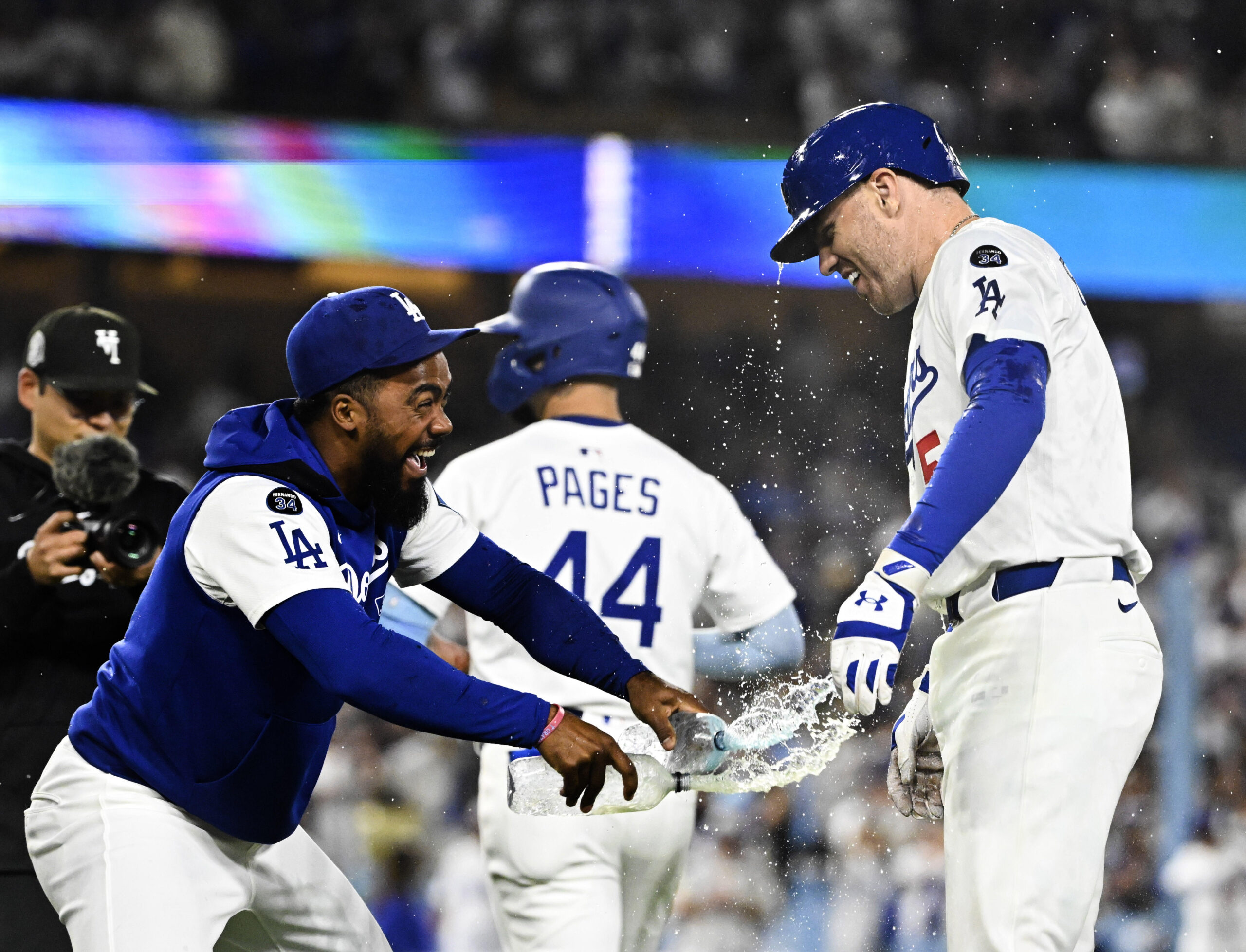 Teoscar Hernández, left, douses Freddie Freeman #5 of the Los...