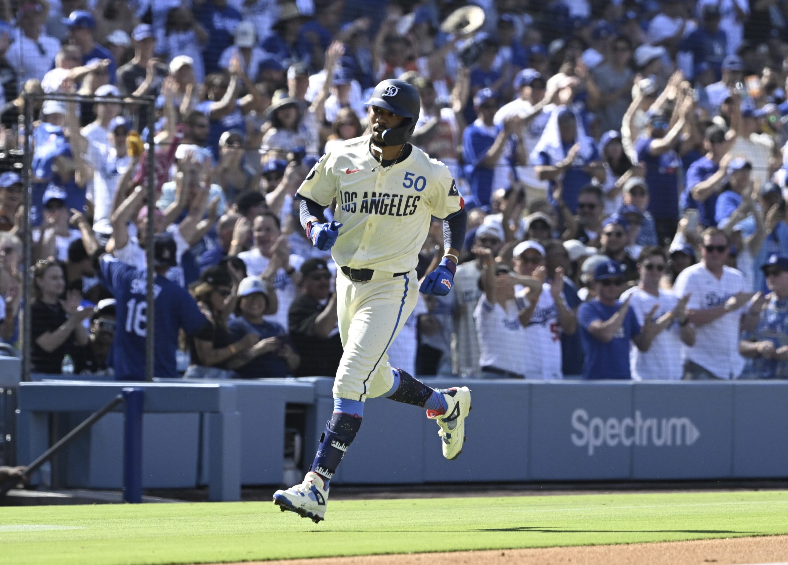 Mookie Betts #50 of the Dodgers rounds third base after...