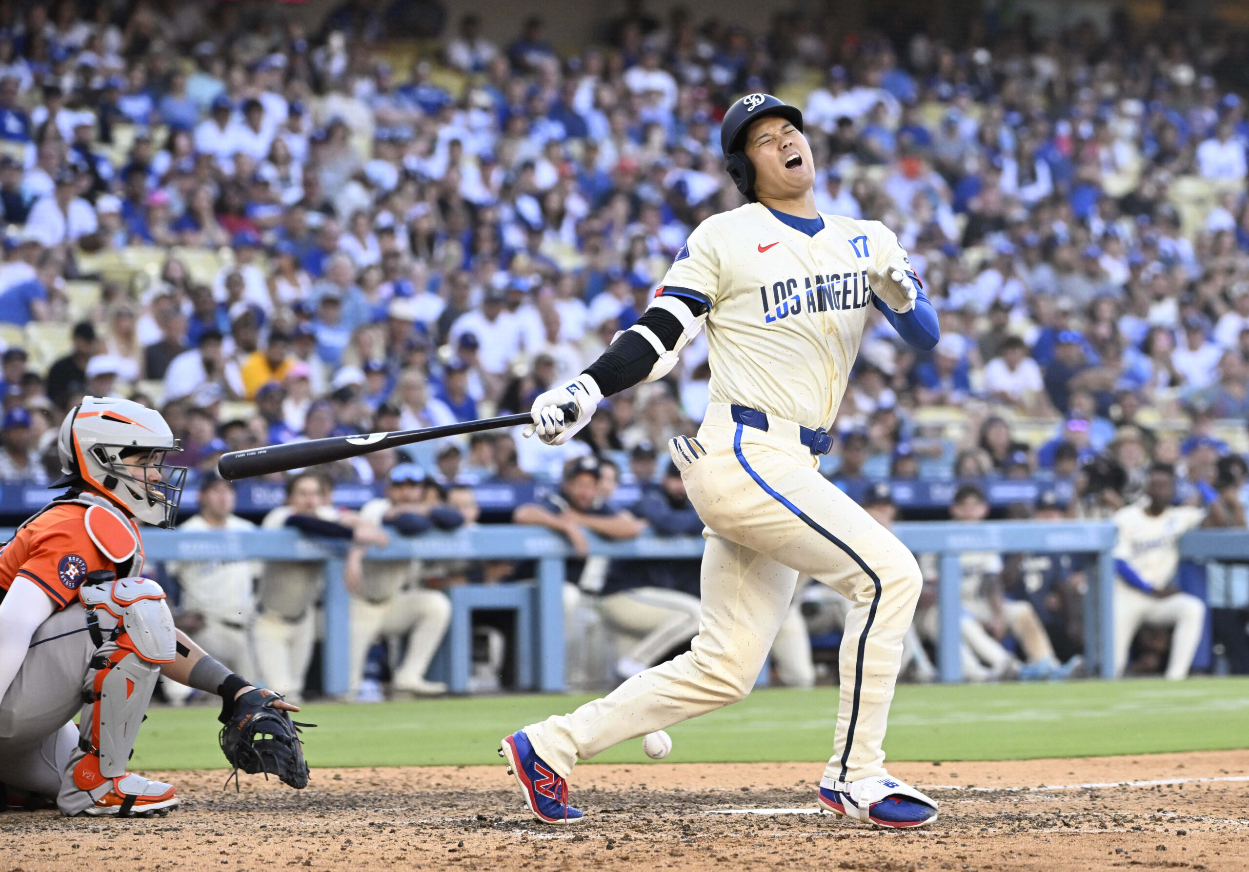 Shohei Ohtani #17 of the Dodgers grimaces as he fouls...