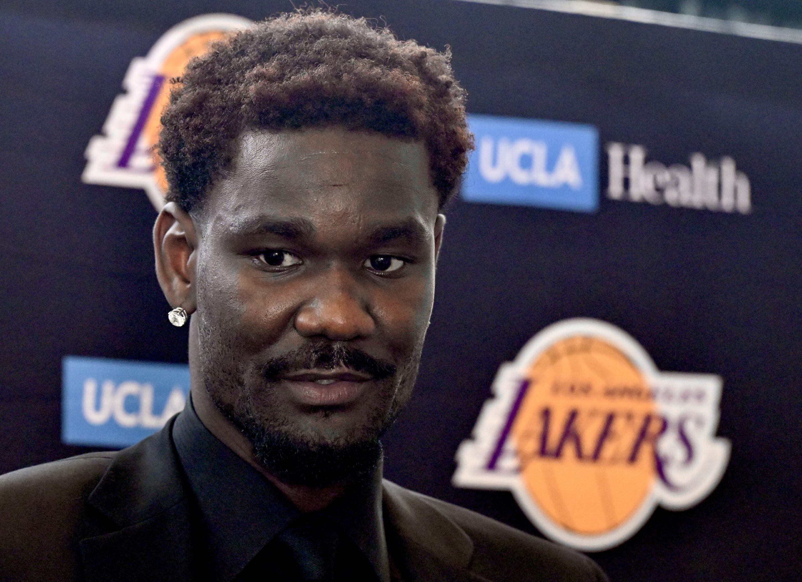New Lakers center Deandre Ayton listens to a reporter’s question...
