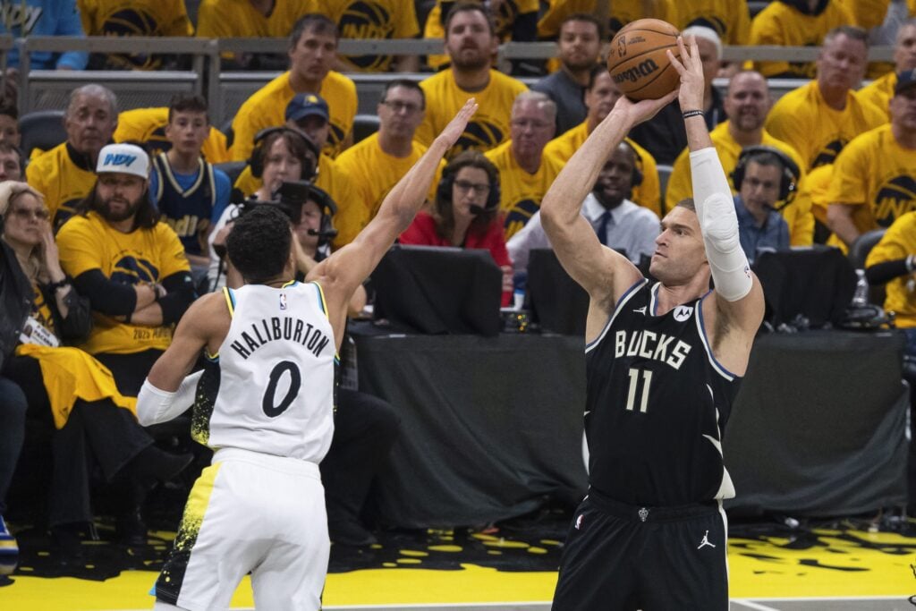 Apr 19, 2025; Indianapolis, Indiana, USA; Milwaukee Bucks center Brook Lopez (11) shoots the ball while Indiana Pacers guard Tyrese Haliburton (0) defends in the first half at Gainbridge Fieldhouse. Mandatory Credit: Trevor Ruszkowski-Imagn Images