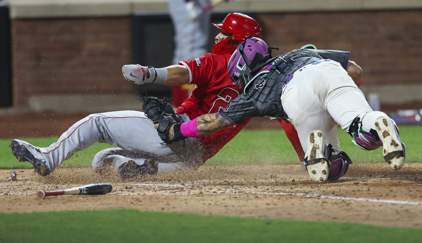 Angels star Mike Trout, left, is tagged out at home...