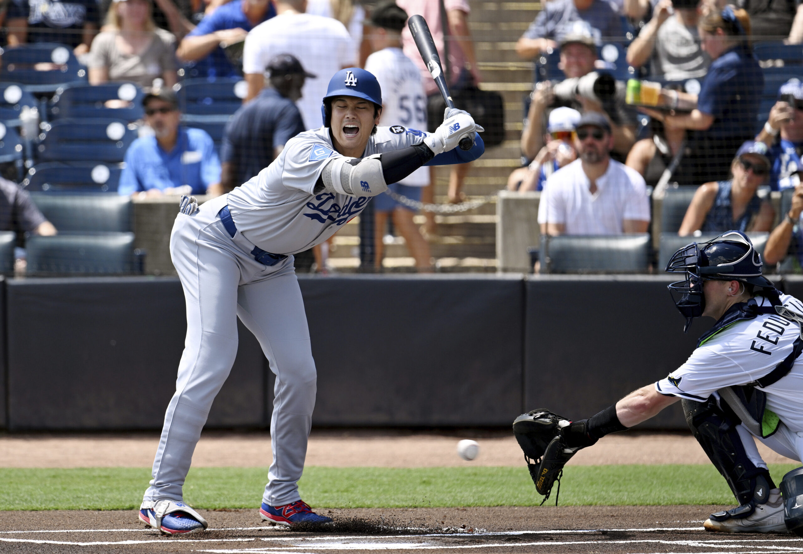 Dodgers’ Shohei Ohtani moves back to avoid an inside pitch...