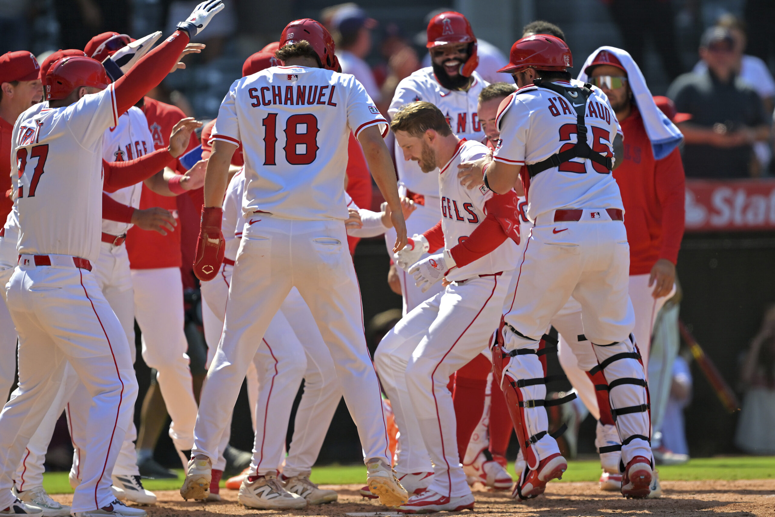 Angels’ Taylor Ward, center right, celebrates at home plate after...