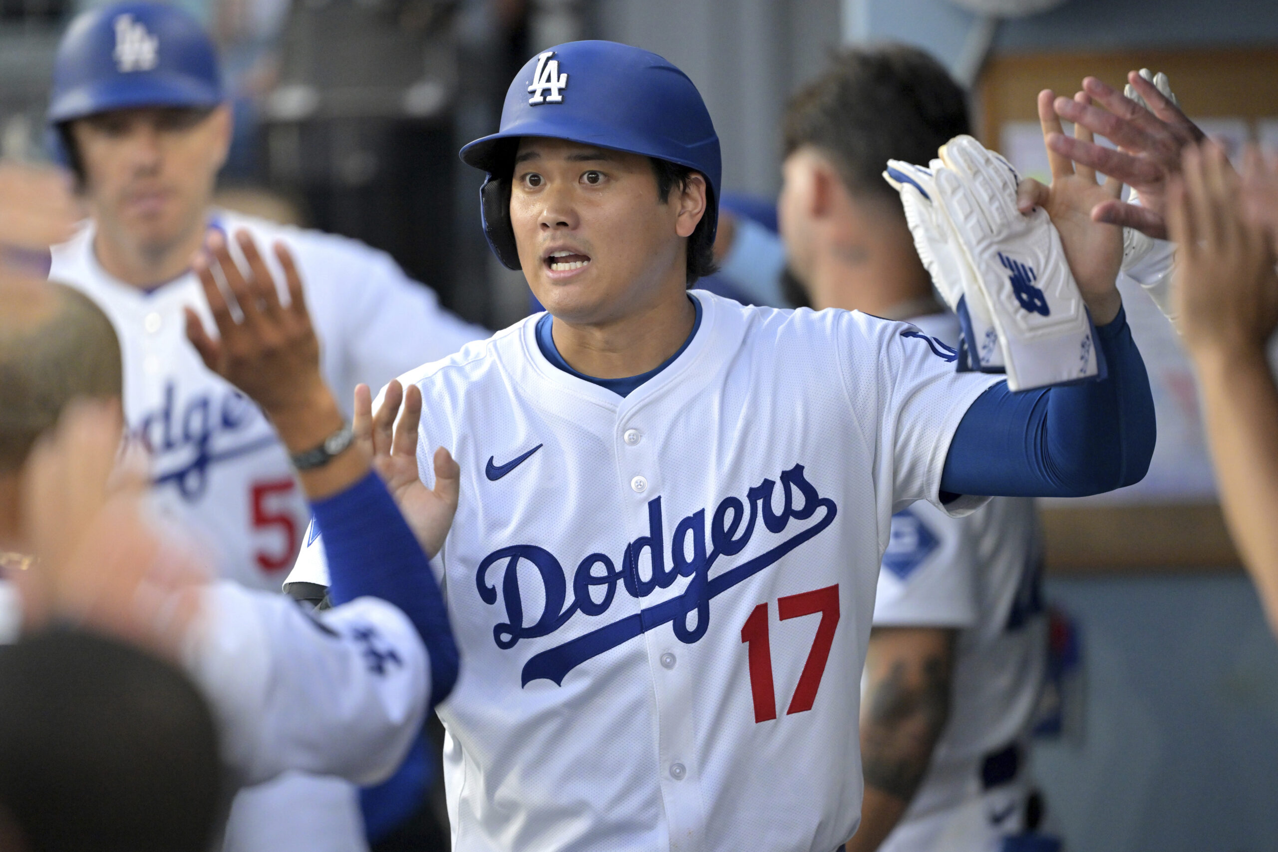 Los Angeles Dodgers’ Shohei Ohtani is congratulated in the dugout...