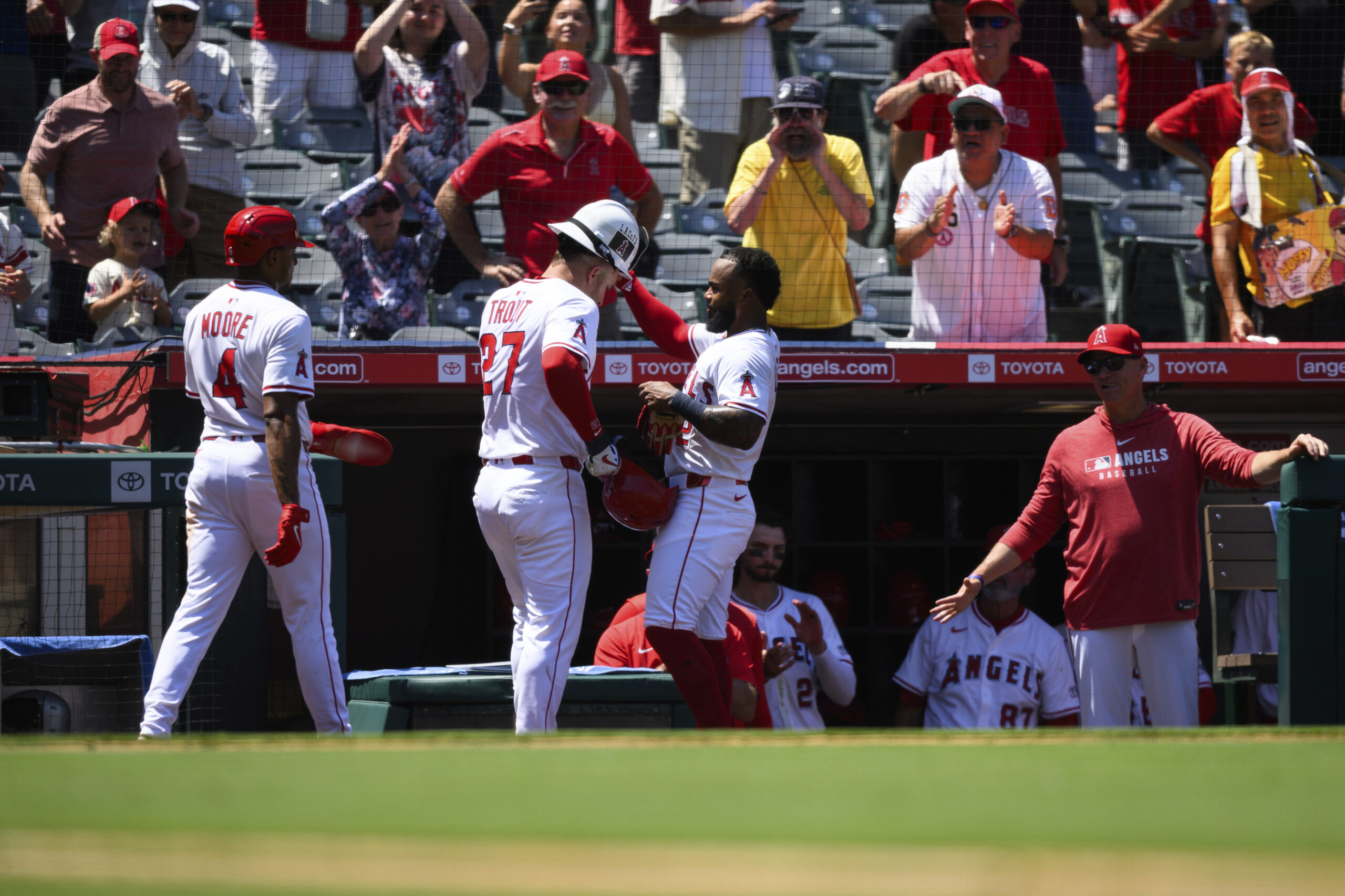 Angels’ Mike Trout, center, is greeted by teammates after hitting...
