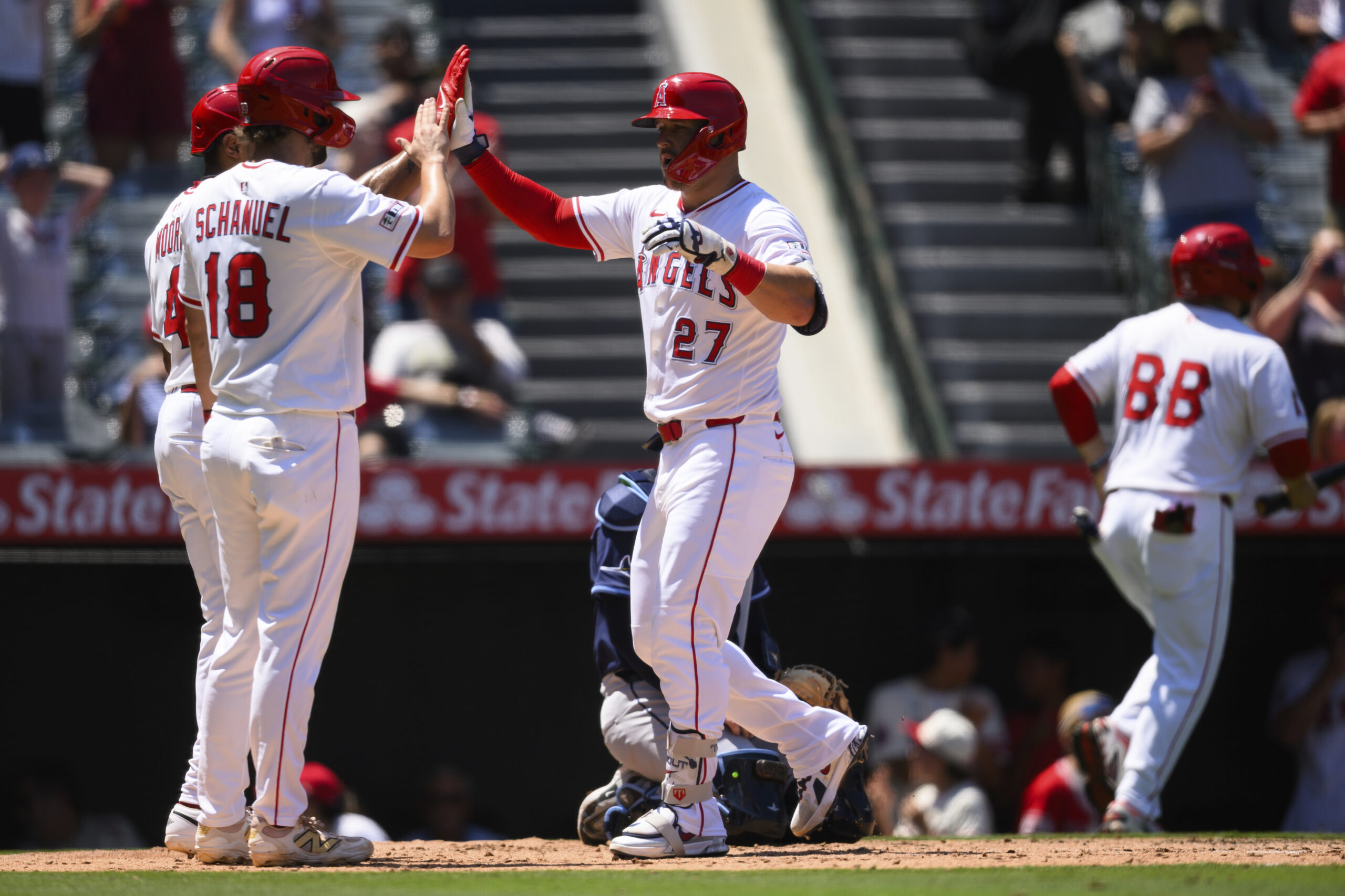 Angels’ Mike Trout, center, is greeted by teammates after hitting...