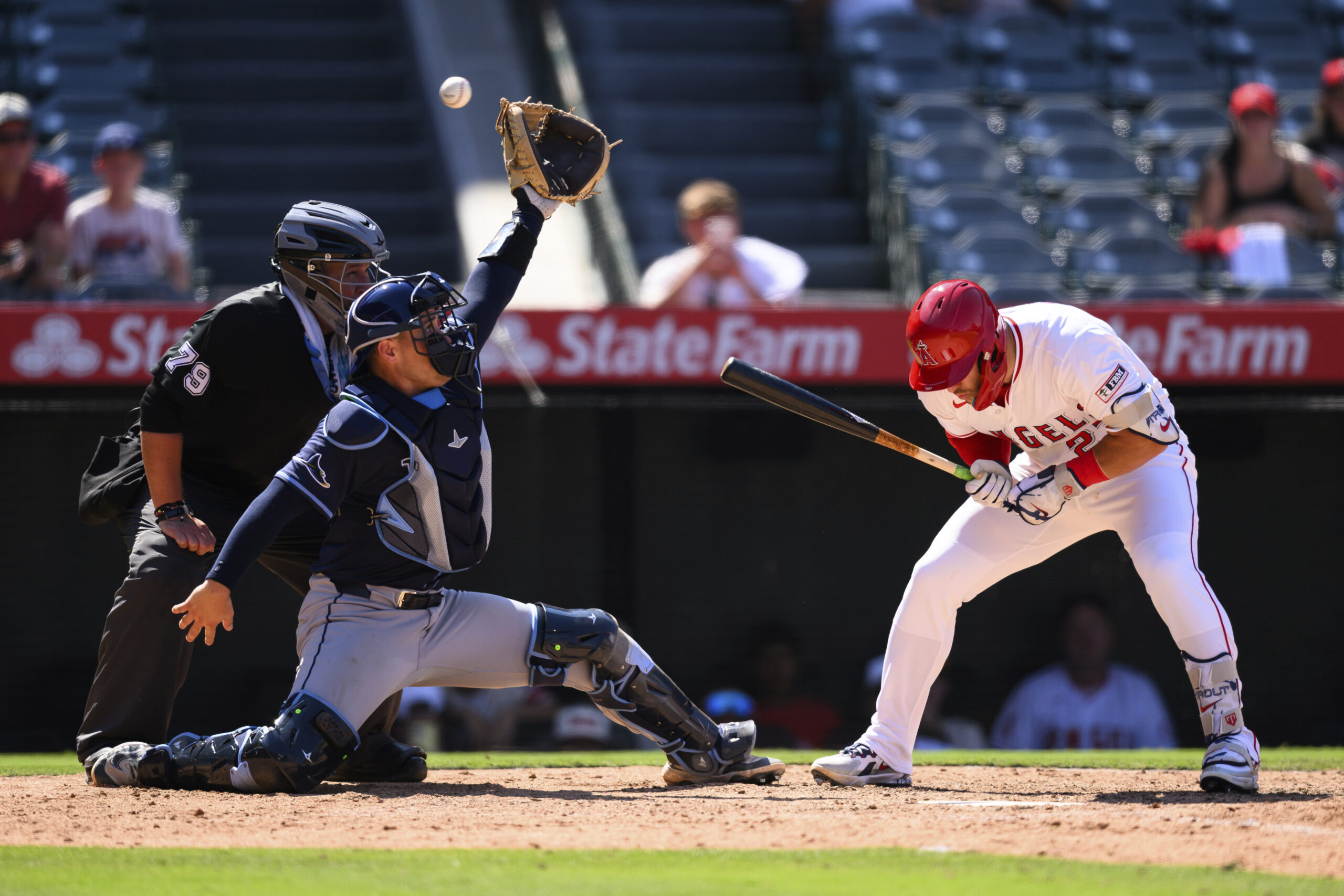 Angels’ Mike Trout, right, dodges a wild pitch during the...