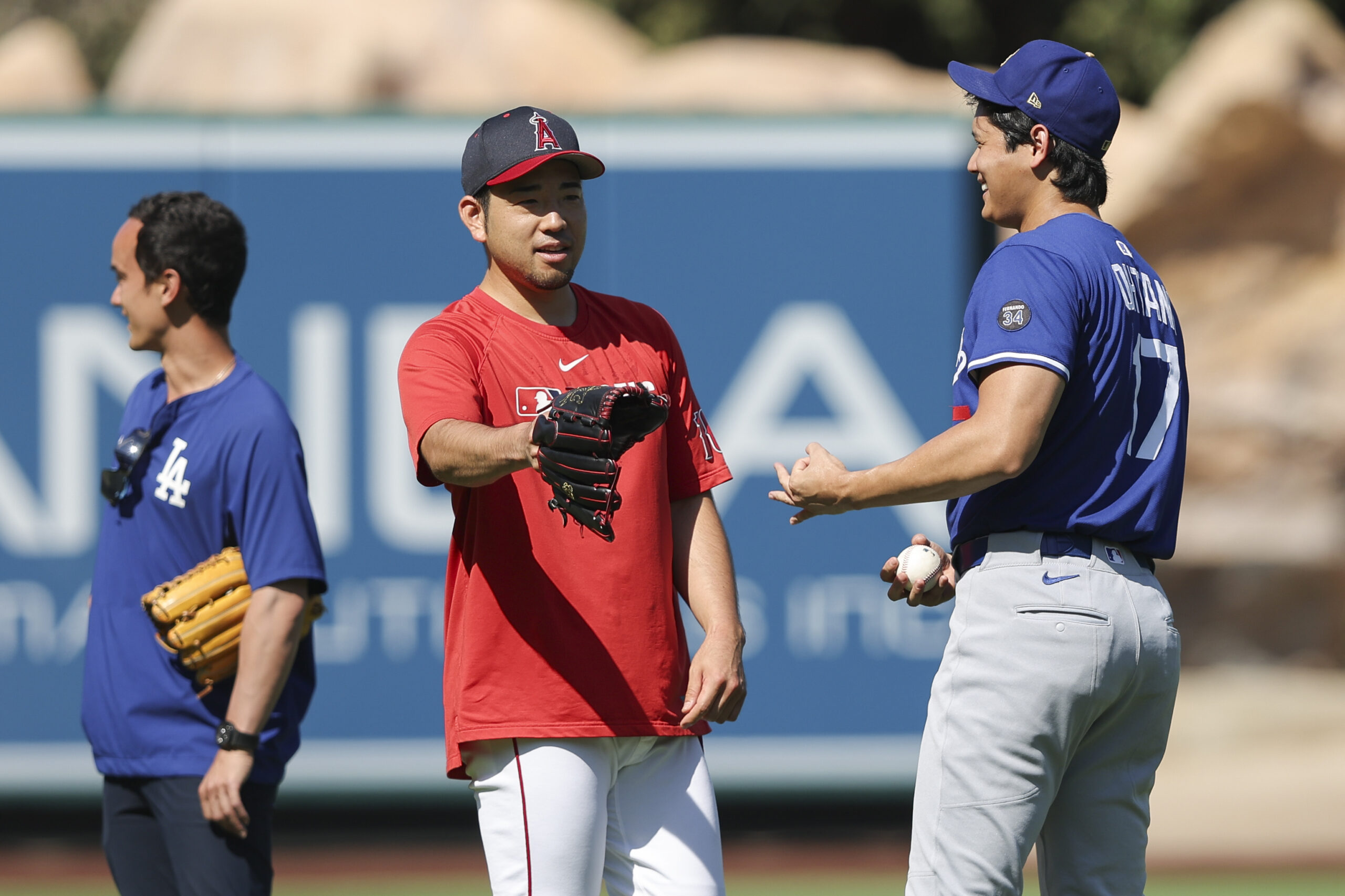 Angels pitcher Yusei Kikuchi, center, gestures while speaking with Dodgers...