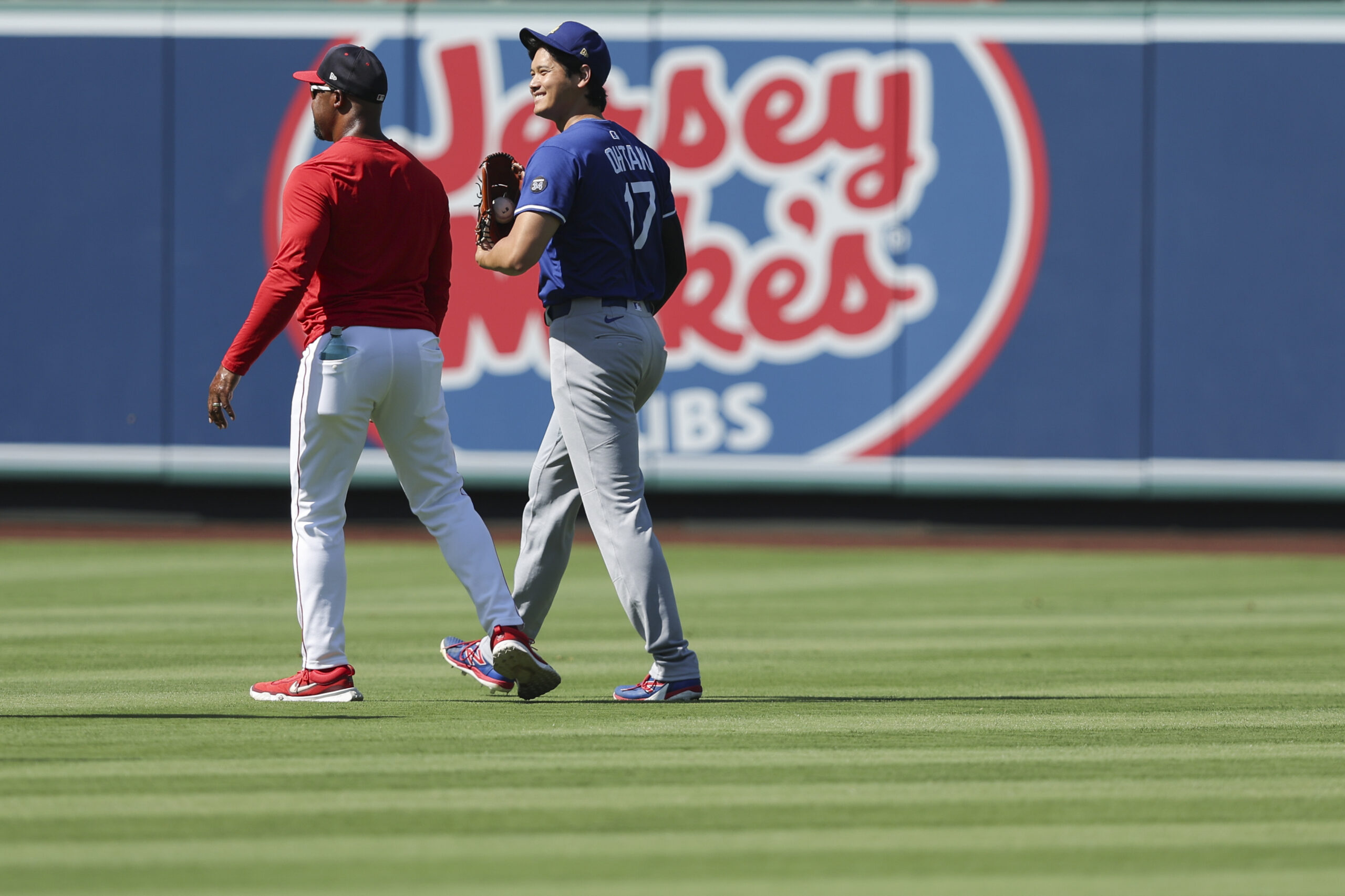 Dodgers star Shohei Ohtani, right, chats with Angels third base...