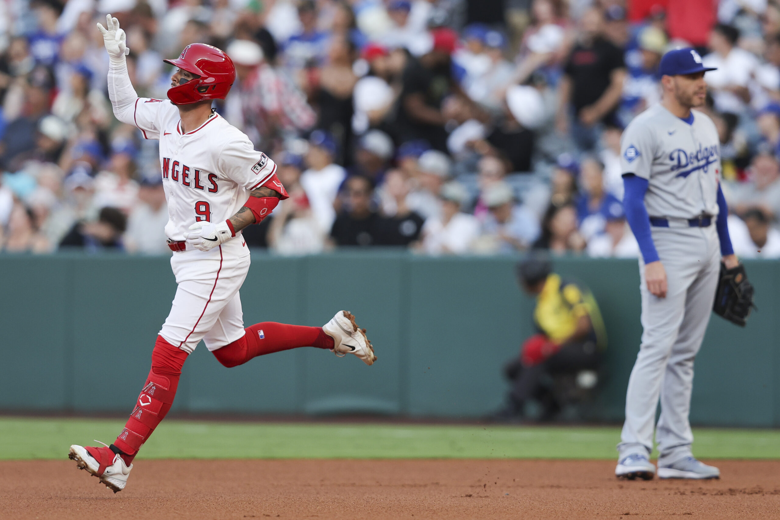 The Angels’ Zach Neto, left, gestures while running the bases...
