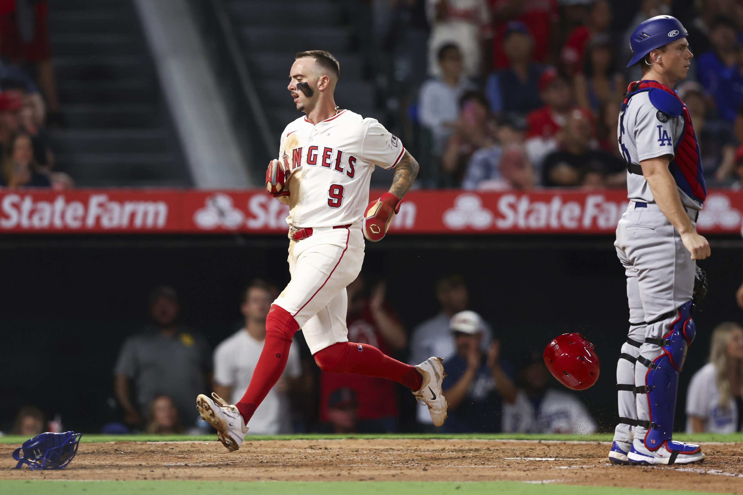 The Angels’ Zach Neto, left, scores on a two-run single...