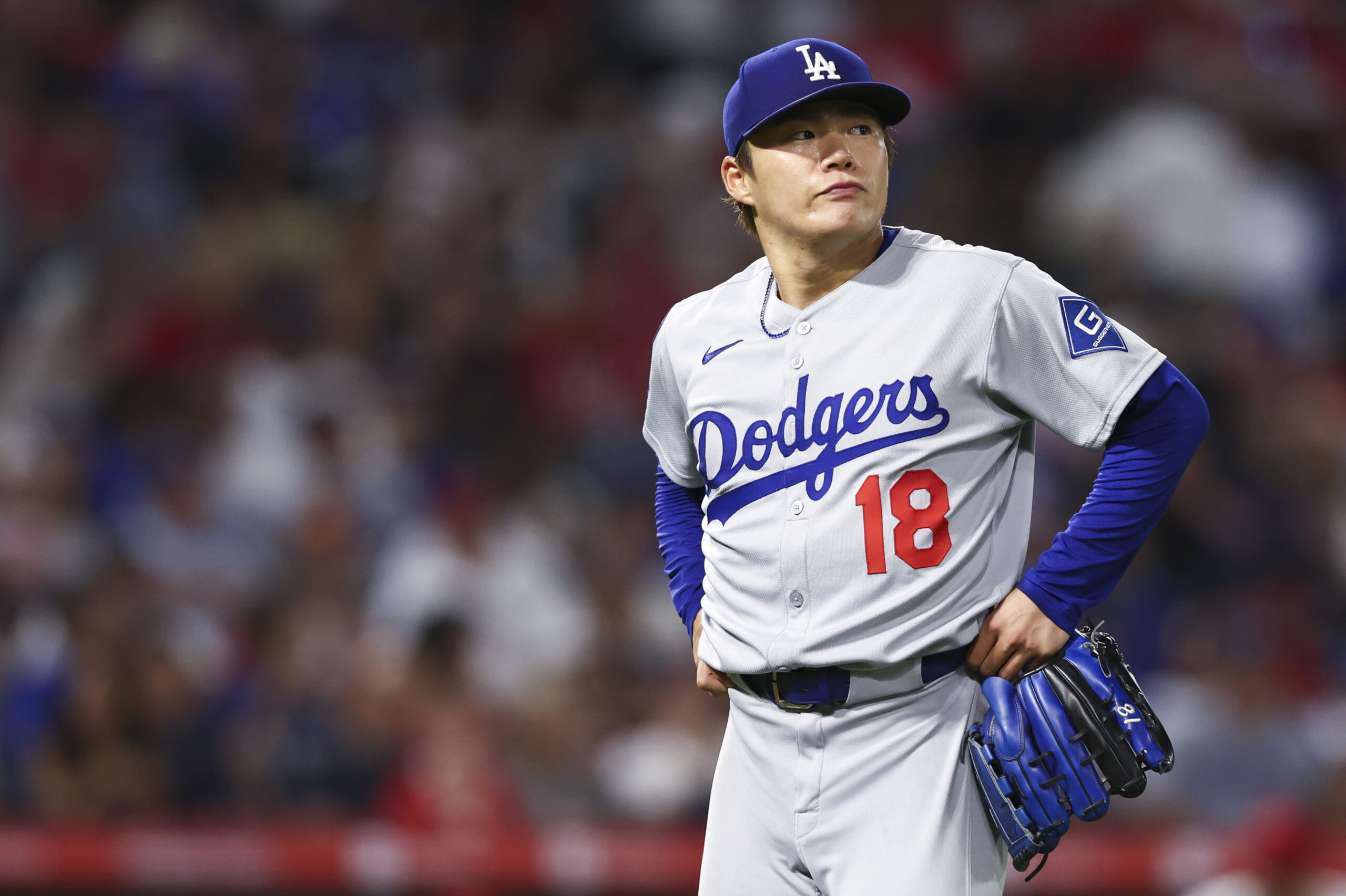 Dodgers starting pitcher Yoshinobu Yamamoto walks toward the dugout during...