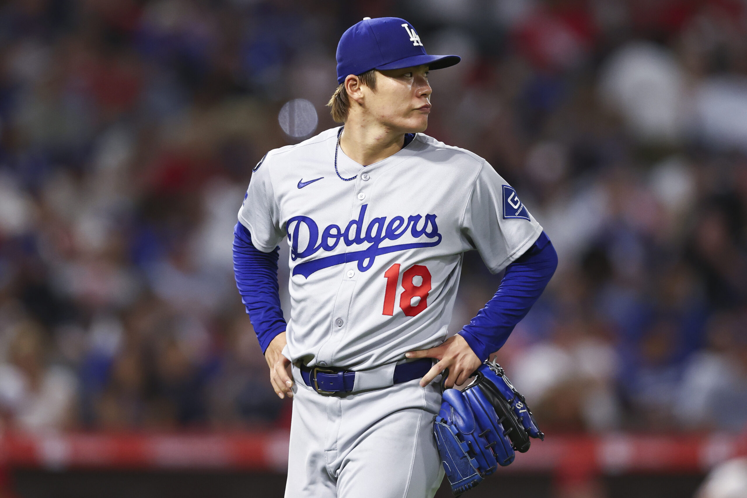 Dodgers starting pitcher Yoshinobu Yamamoto walks toward the dugout during...