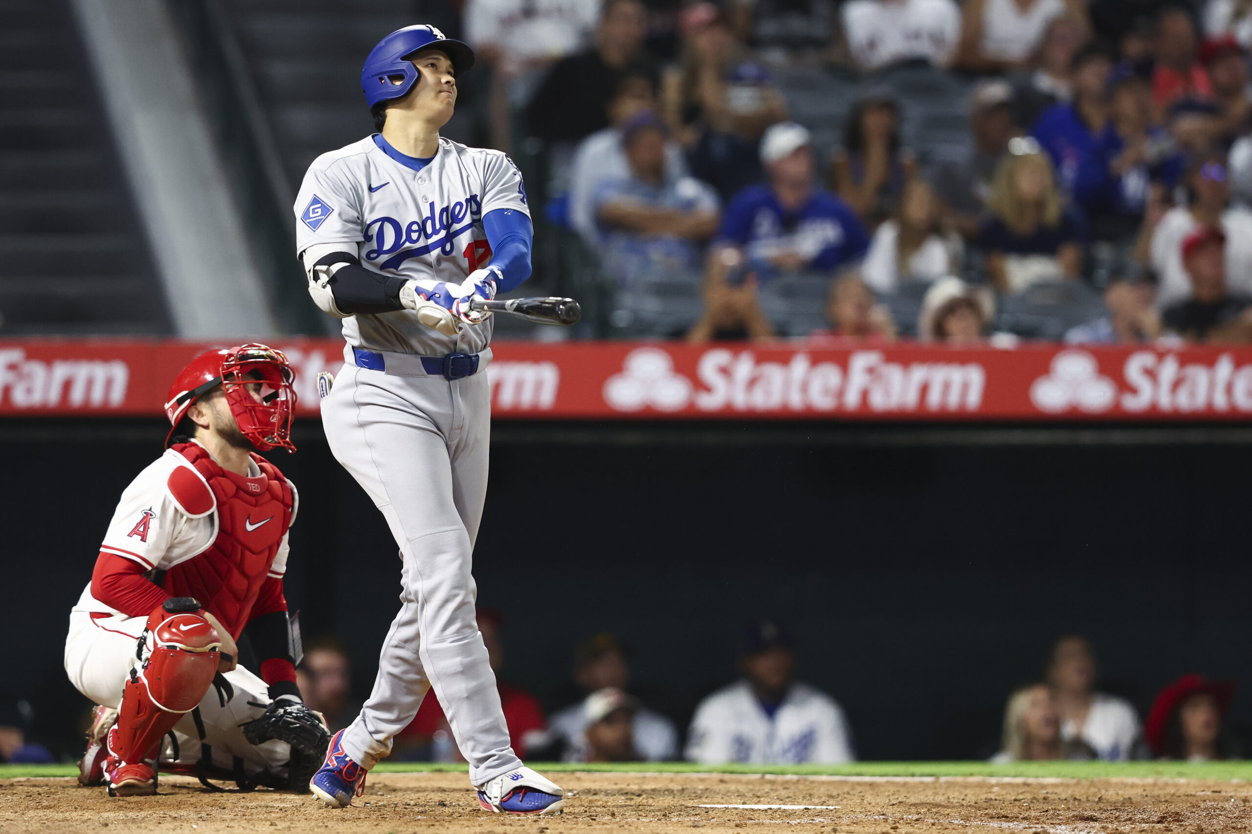 Dodgers star Shohei Ohtani watches the flight of his solo...