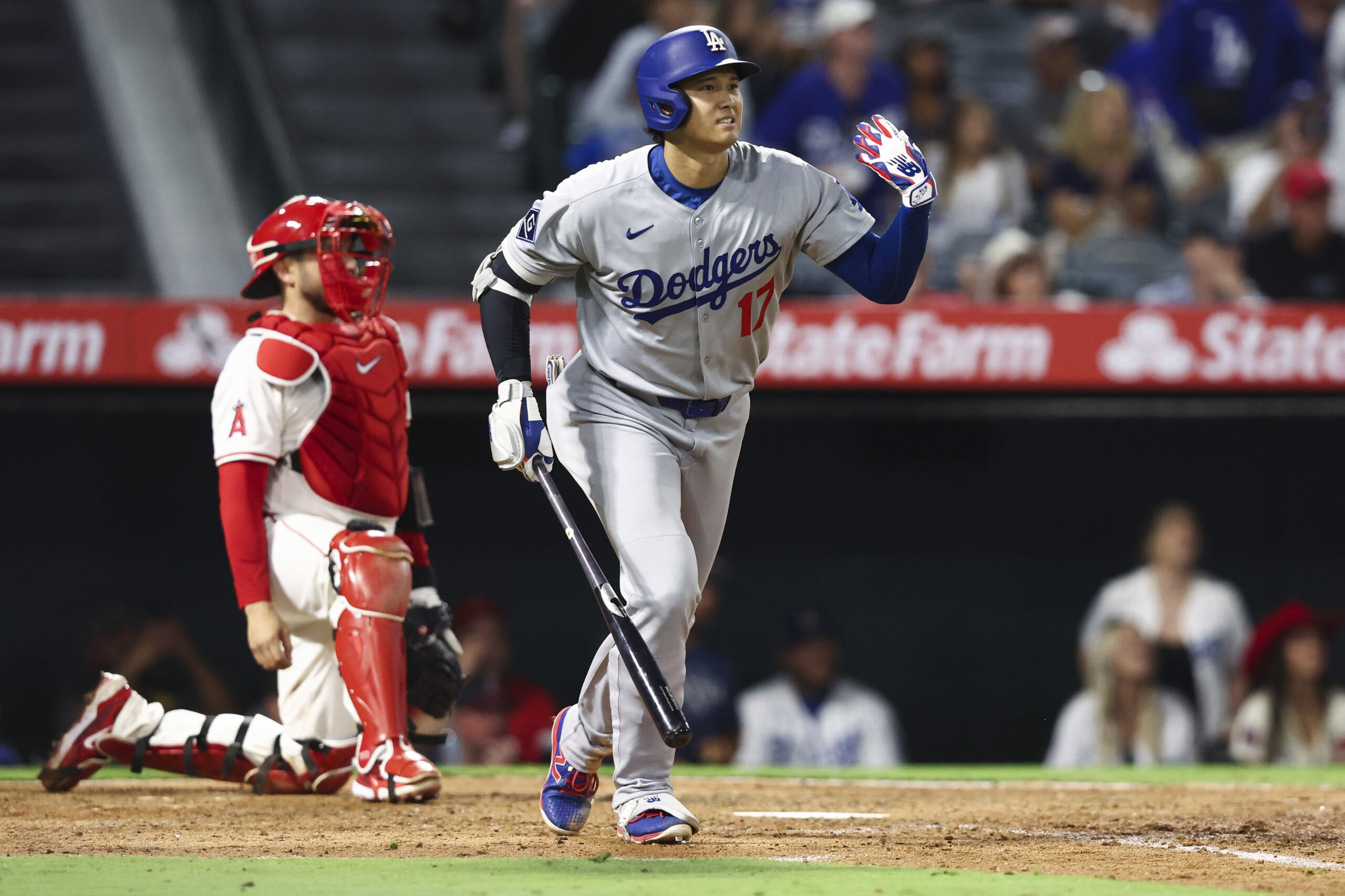 Dodgers star Shohei Ohtani gestures as he watches the flight...