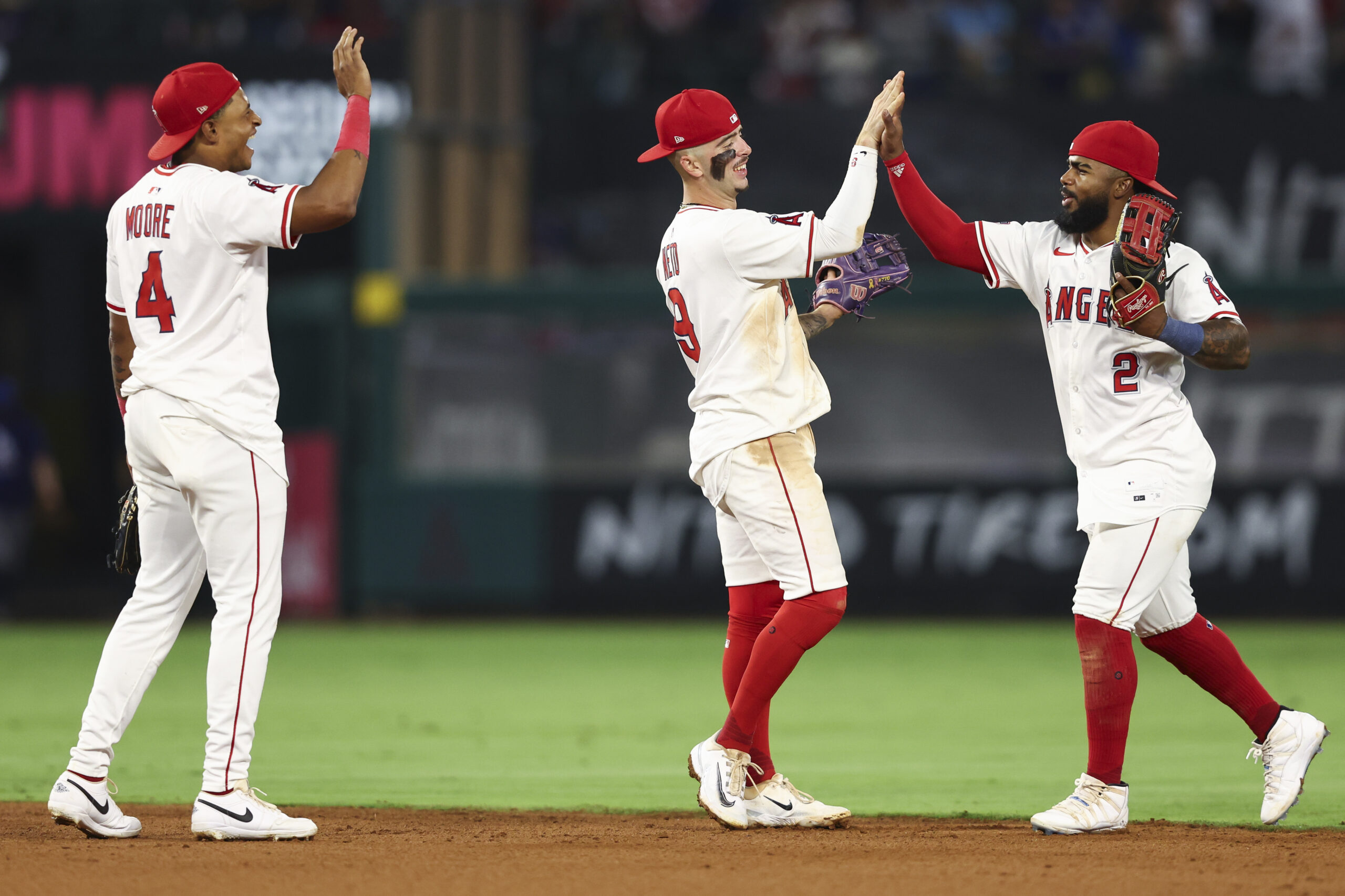 Angels second baseman Christian Moore, left, shortstop Zach Neto, center,...