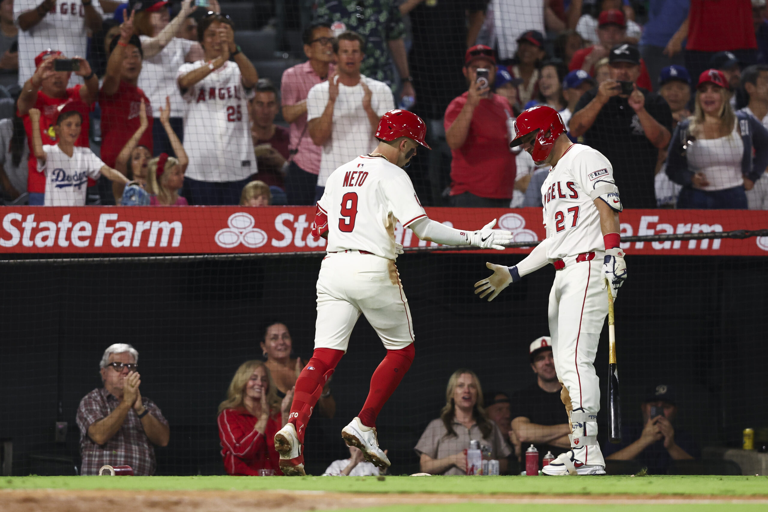 The Angels’ Zach Neto, left, celebrates with teammate Mike Trout...
