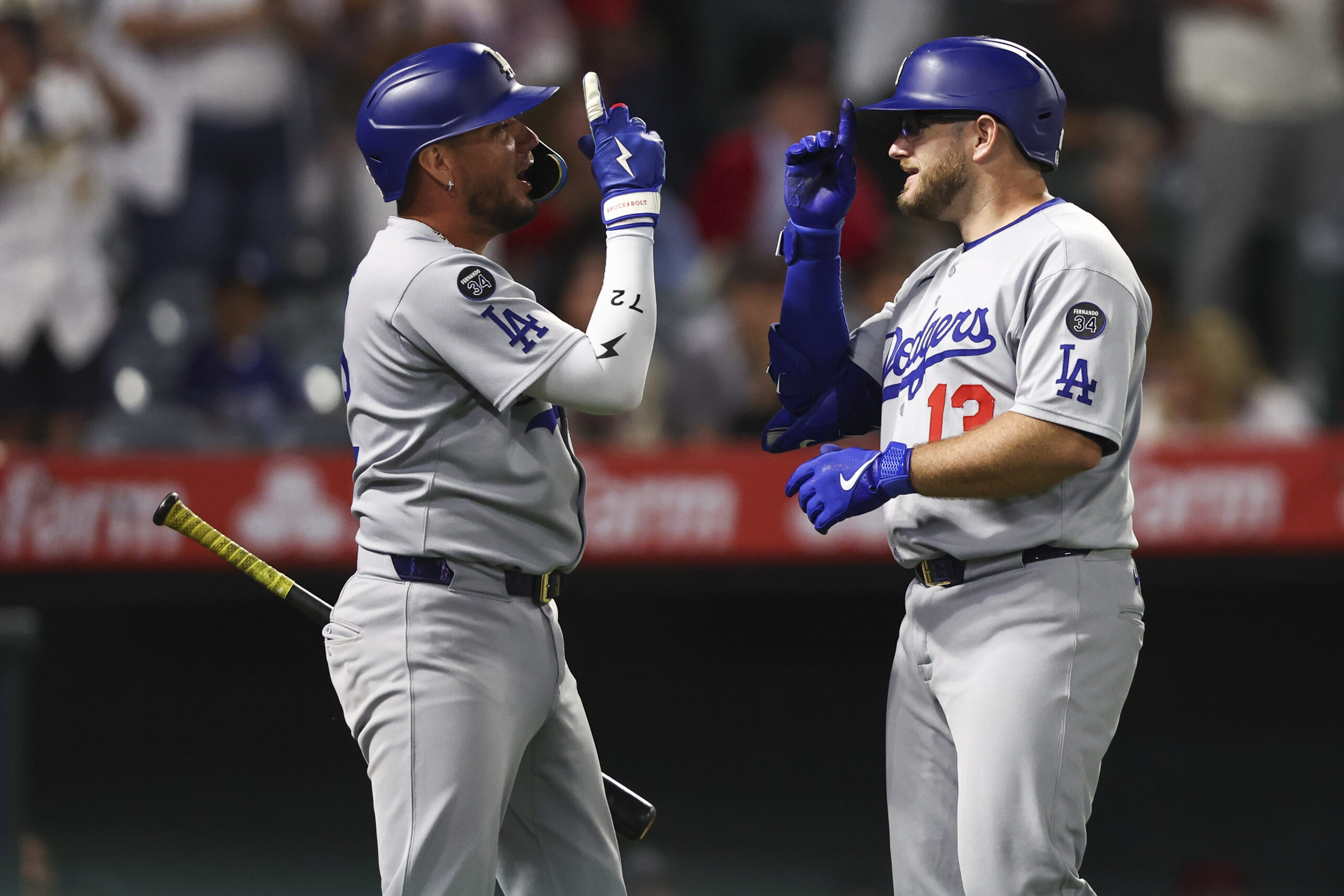 The Dodgers’ Max Muncy, right, celebrates with teammate Miguel Rojas...