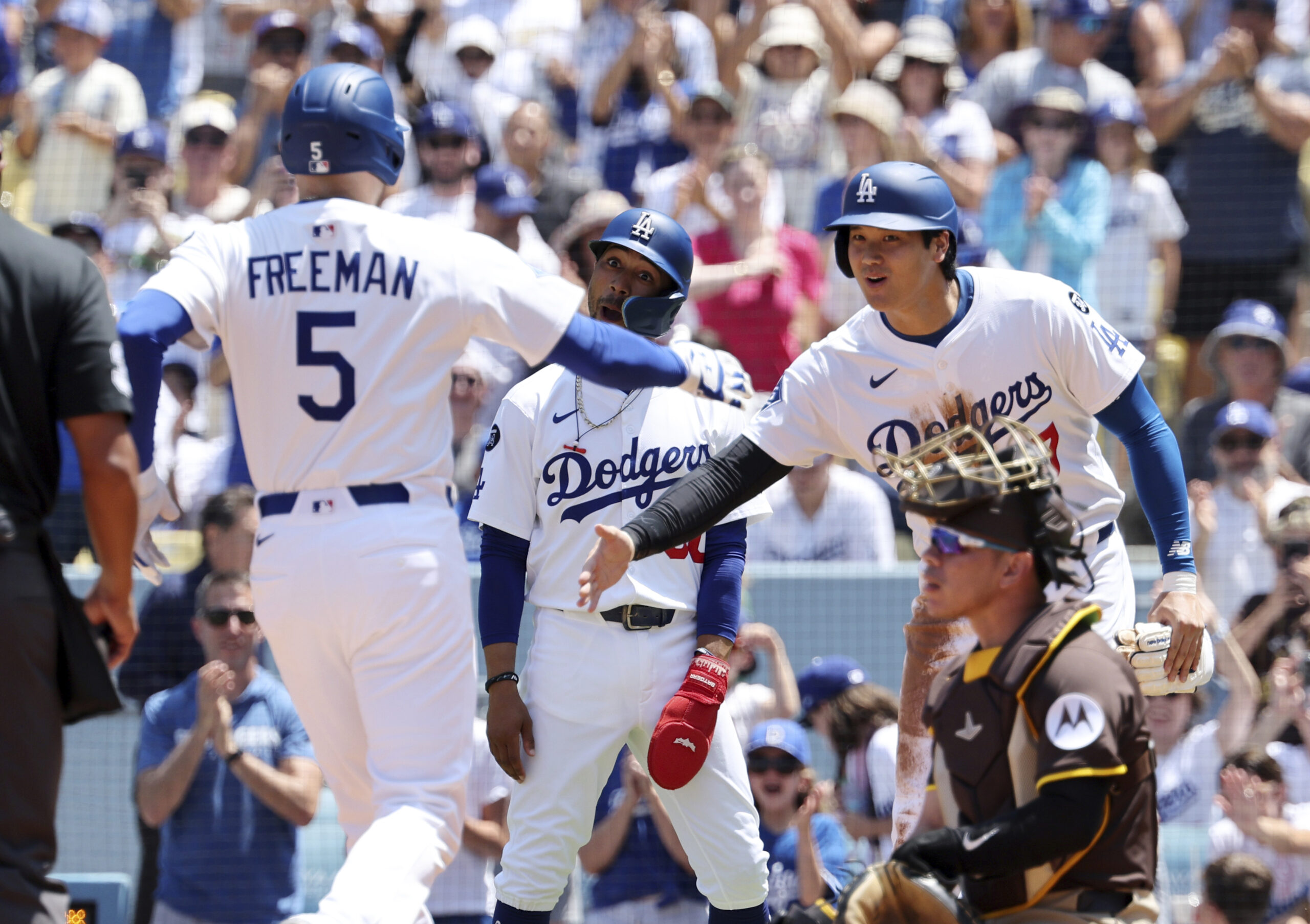 The Dodgers’ Freddie Freeman, left, is congratulated by Mookie Betts,...