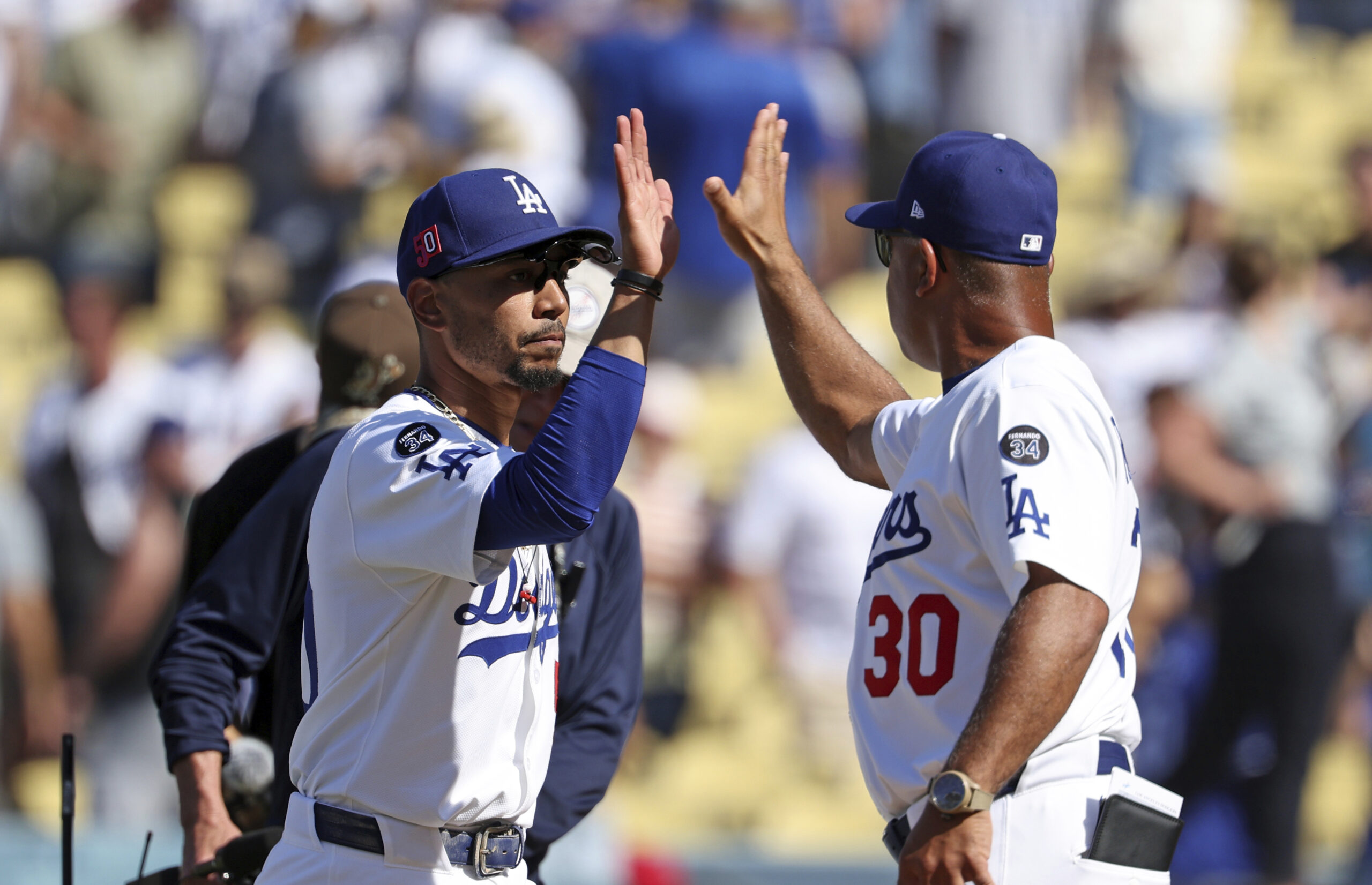 Dodgers shortstop Mookie Betts, left, celebrates with Manager Dave Roberts...