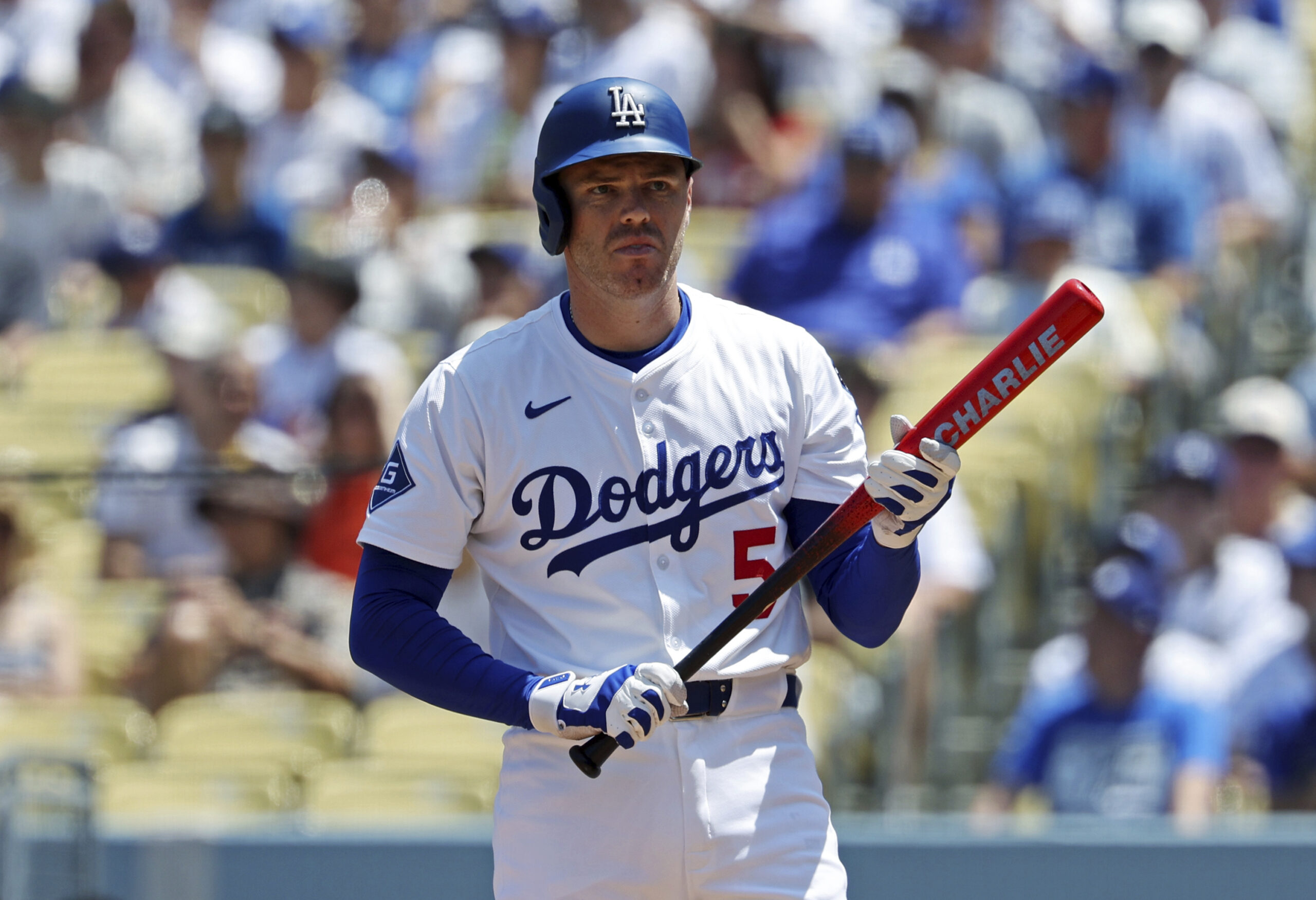 The Dodgers’ Freddie Freeman holds his bat, with his son...