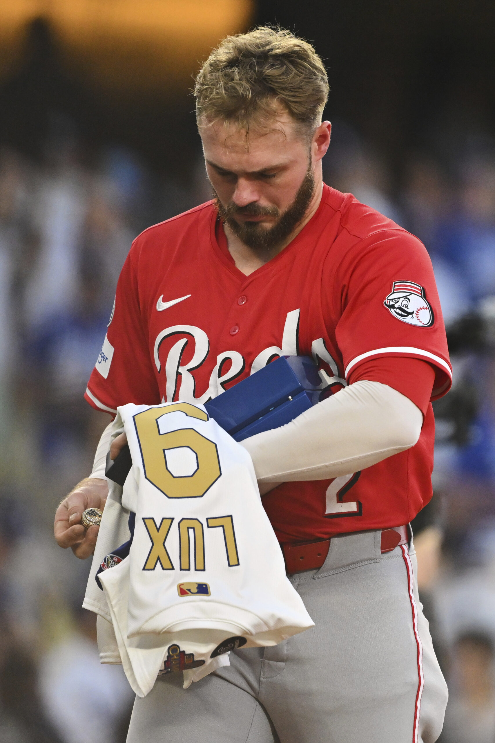 Cincinnati Reds infielder Gavin Lux walks back to the dugout...