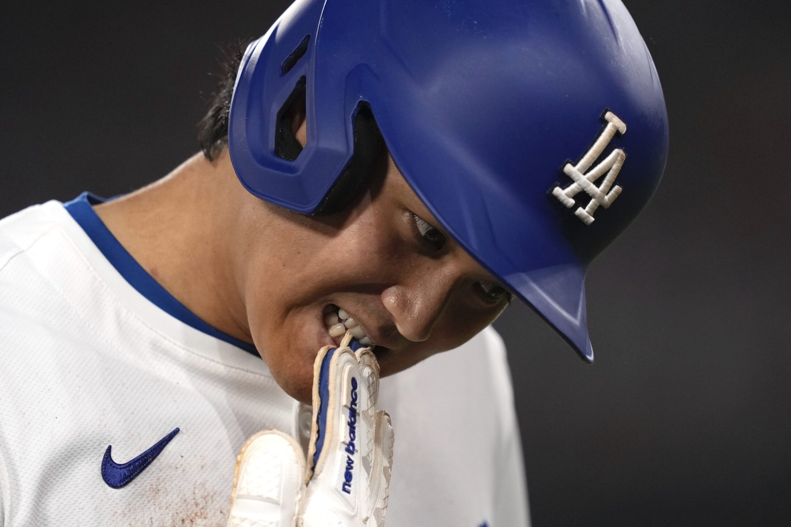 Dodgers star Shohei Ohtani takes his glove off after being...