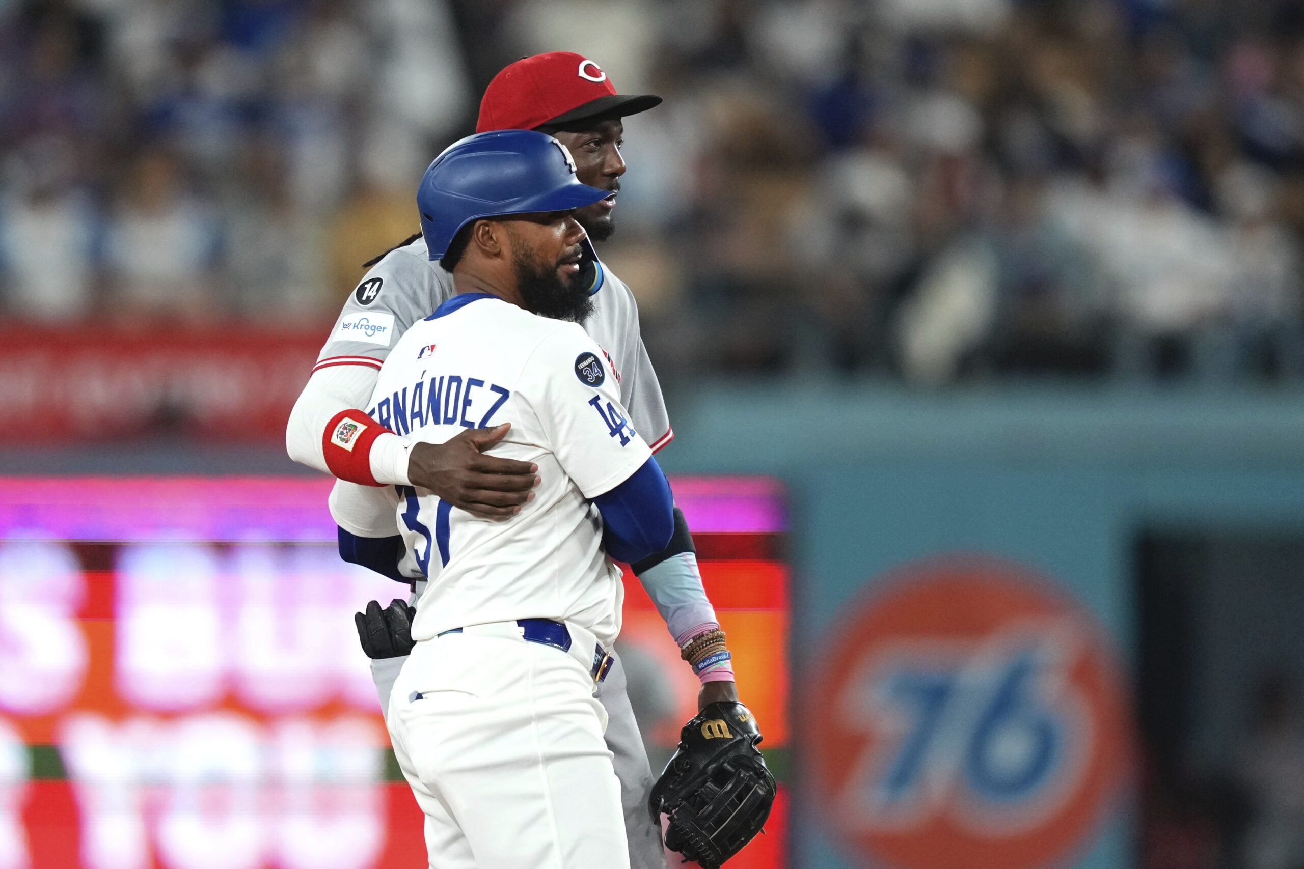 The Dodgers’ Teoscar Hernández, left, and Cincinnati Reds shortstop Elly...