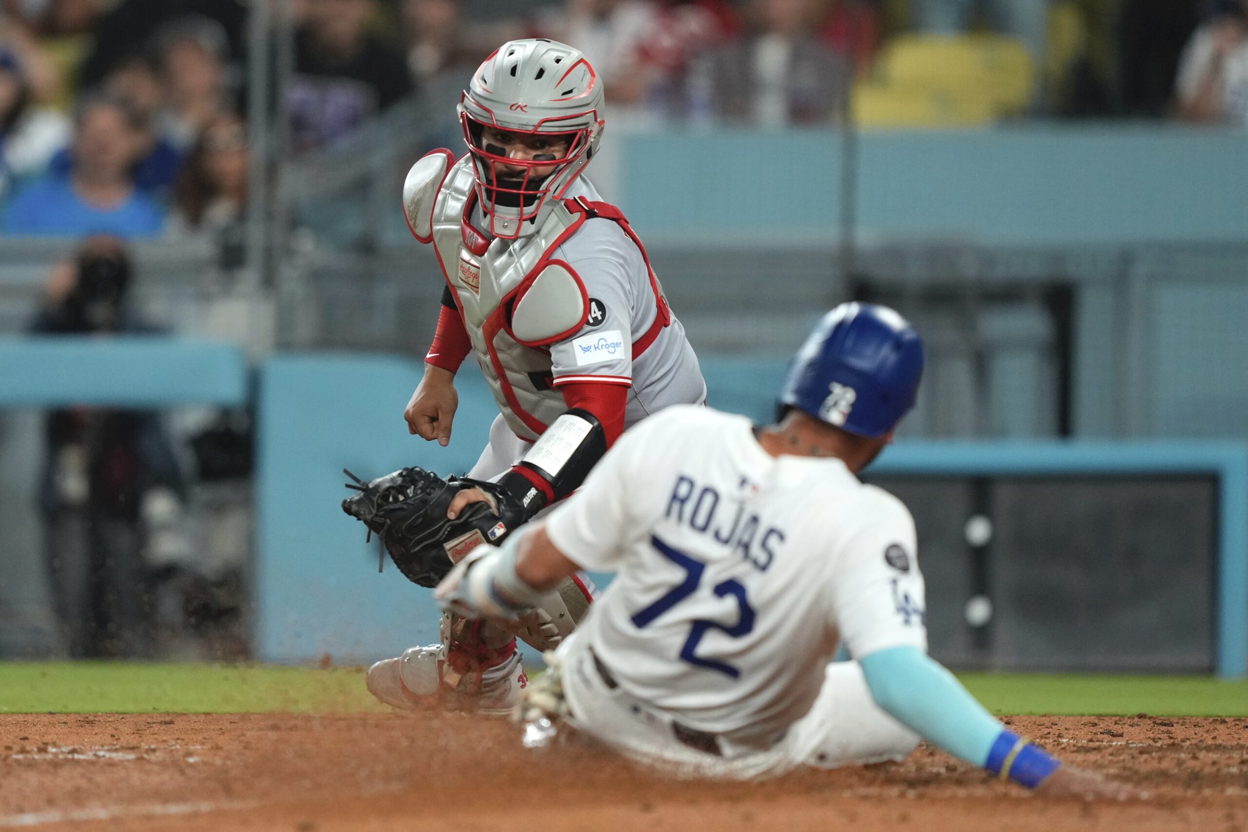 The Dodgers’ Miguel Rojas, right, scores on a single hit...