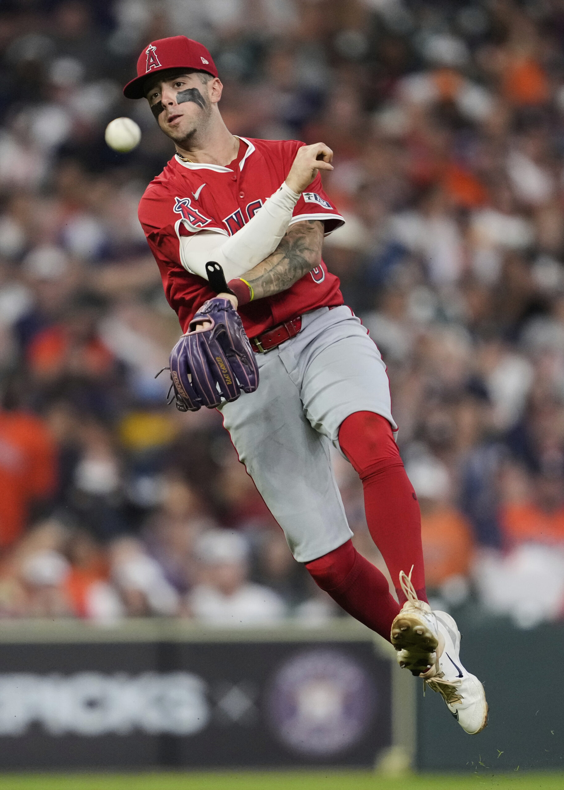 Angels shortstop Zach Neto throws to first to out Houston...