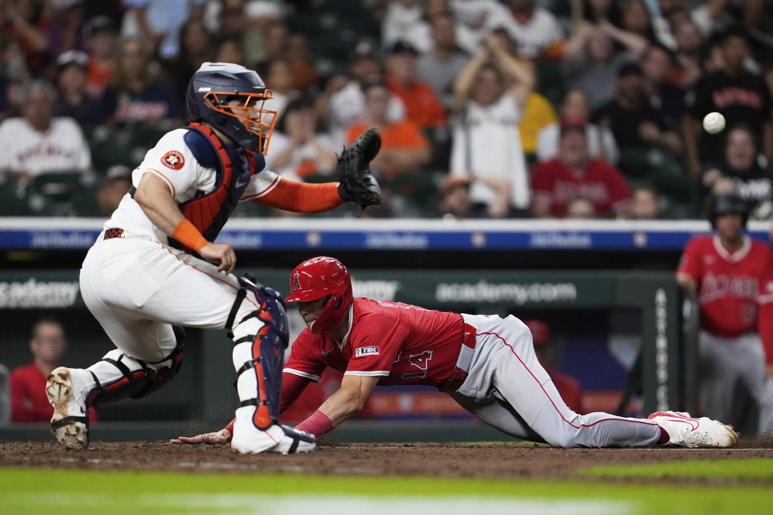 Angels’ Logan O’Hoppe (14) scores ahead of a throw to...