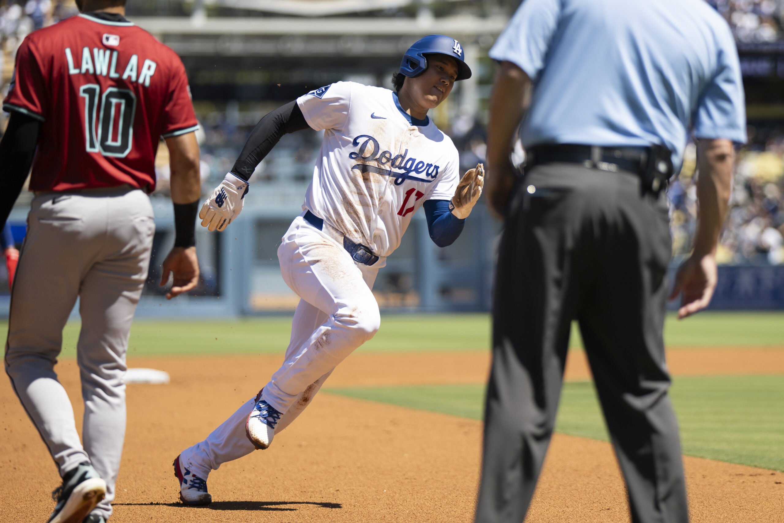 Dodgers’ Shohei Ohtani runs to score on an RBI double...