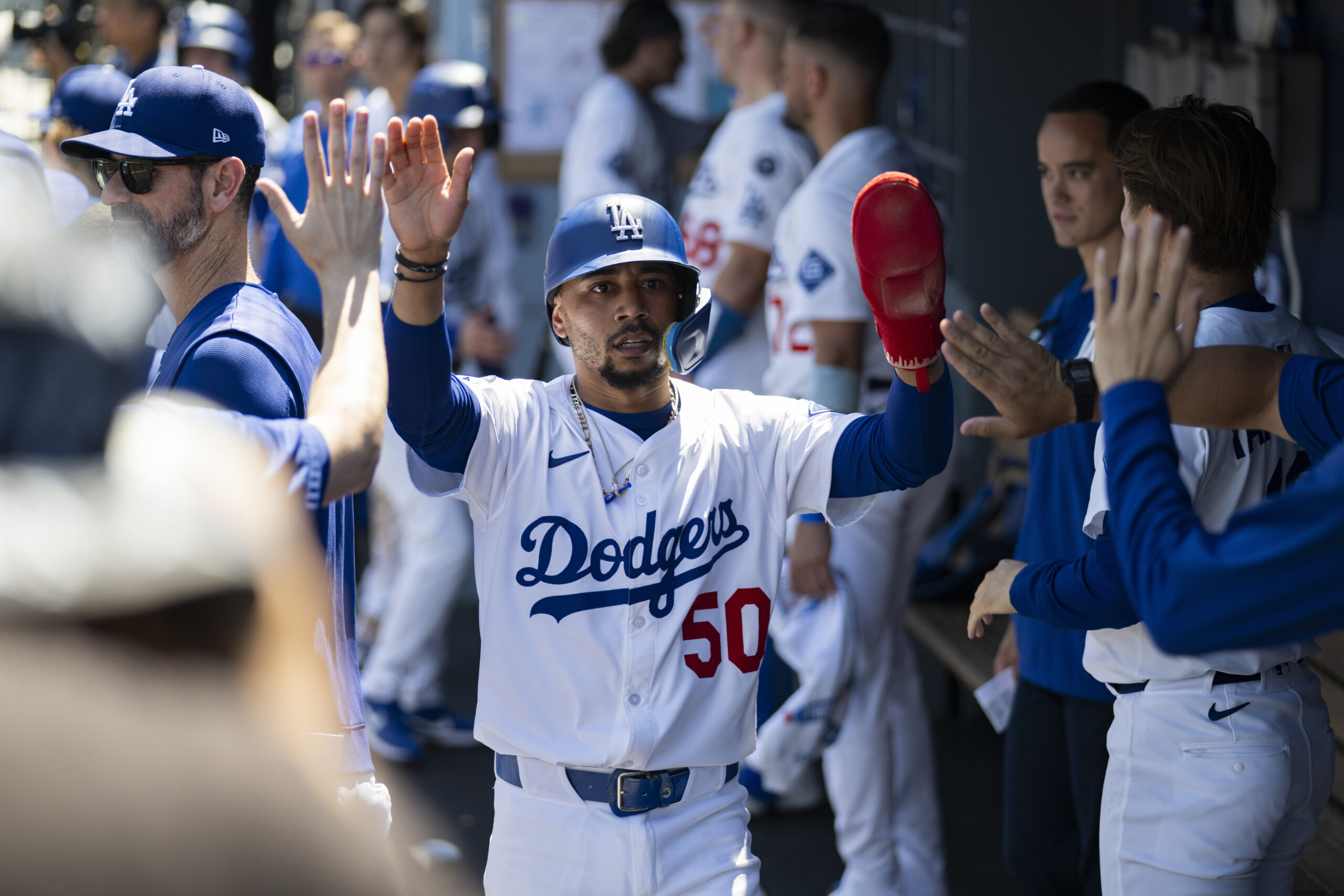 Dodgers’ Mookie Betts is greeted in the dugout after scoring...