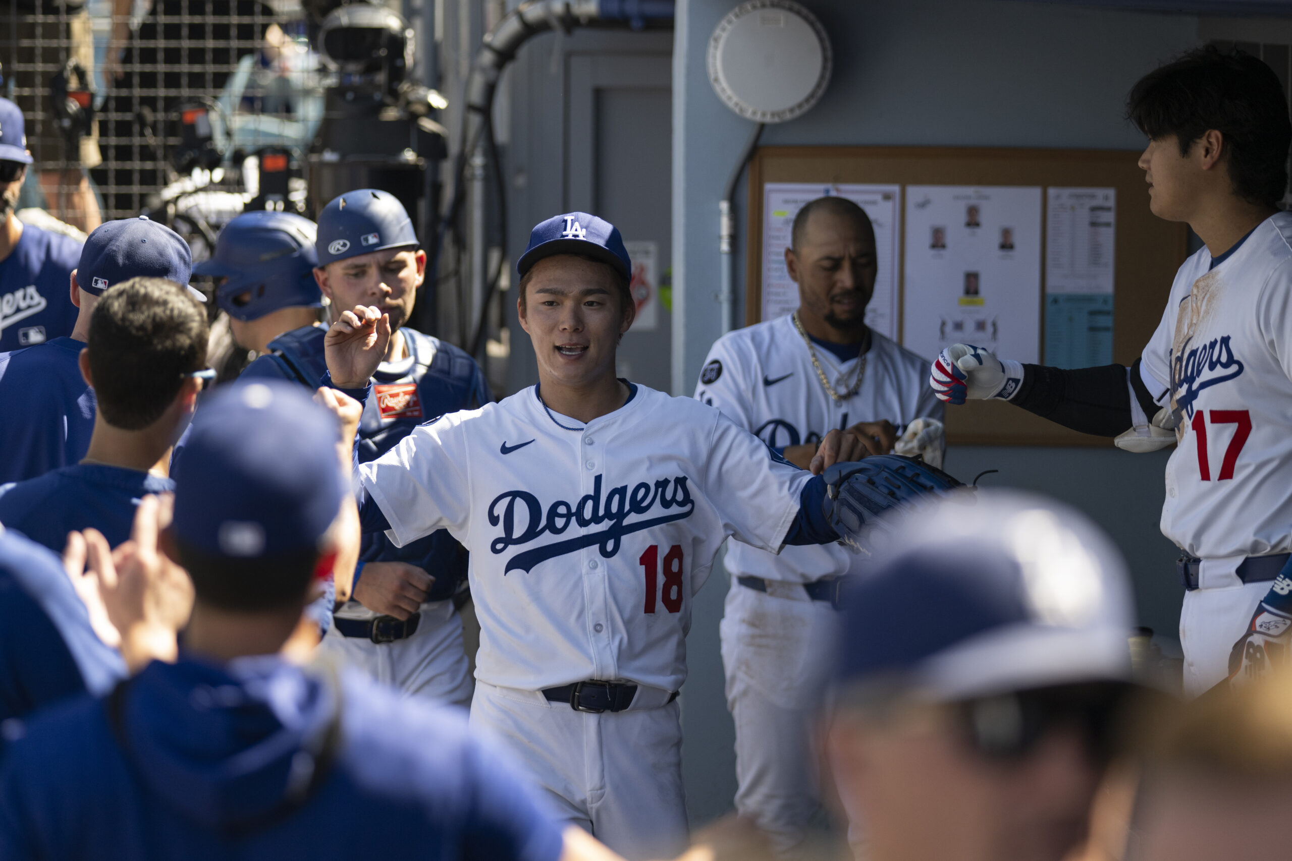 Dodgers starting pitcher Yoshinobu Yamamoto (18) is greeted in the...
