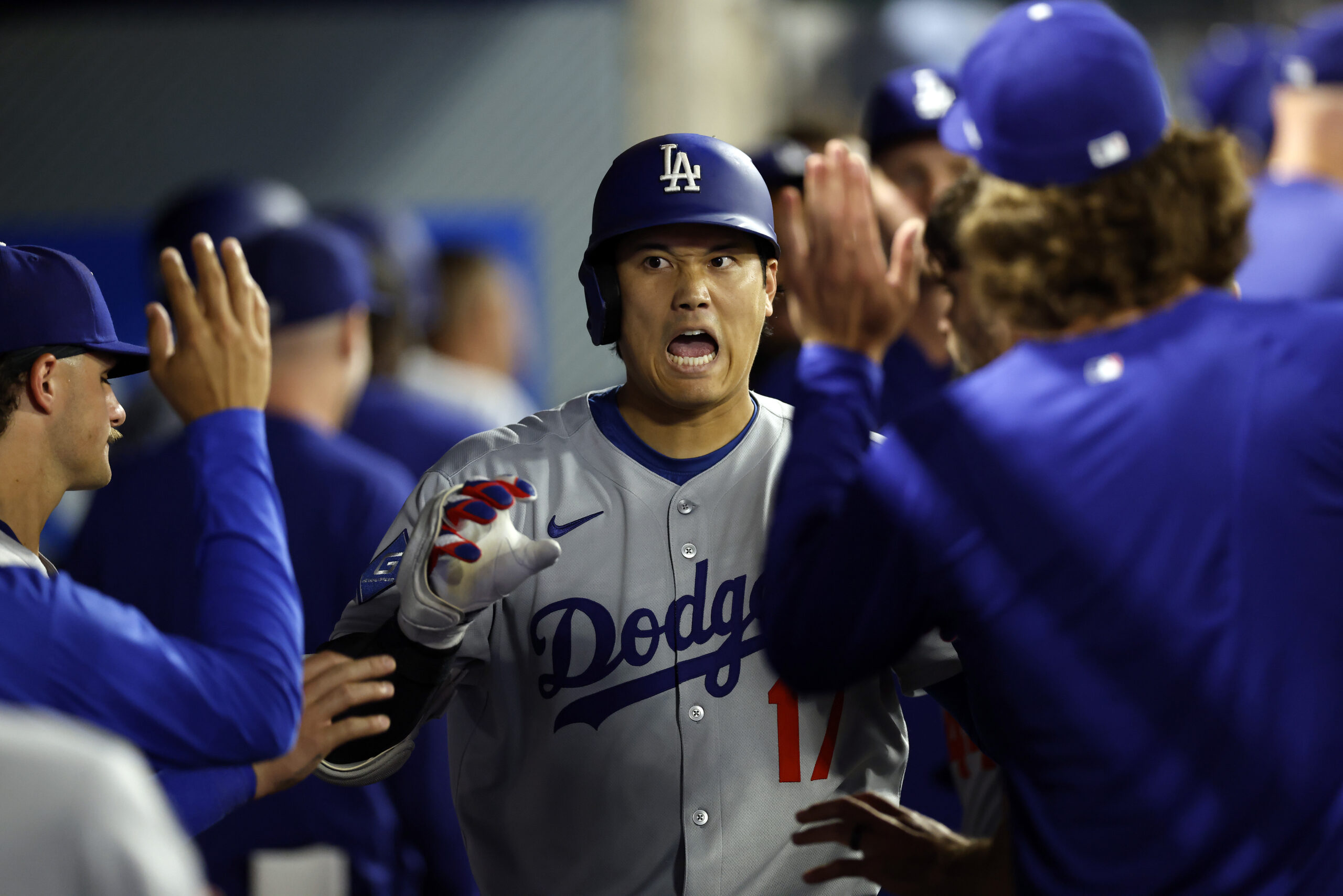 Dodgers star Shohei Ohtani celebrates in the dugout after hitting...