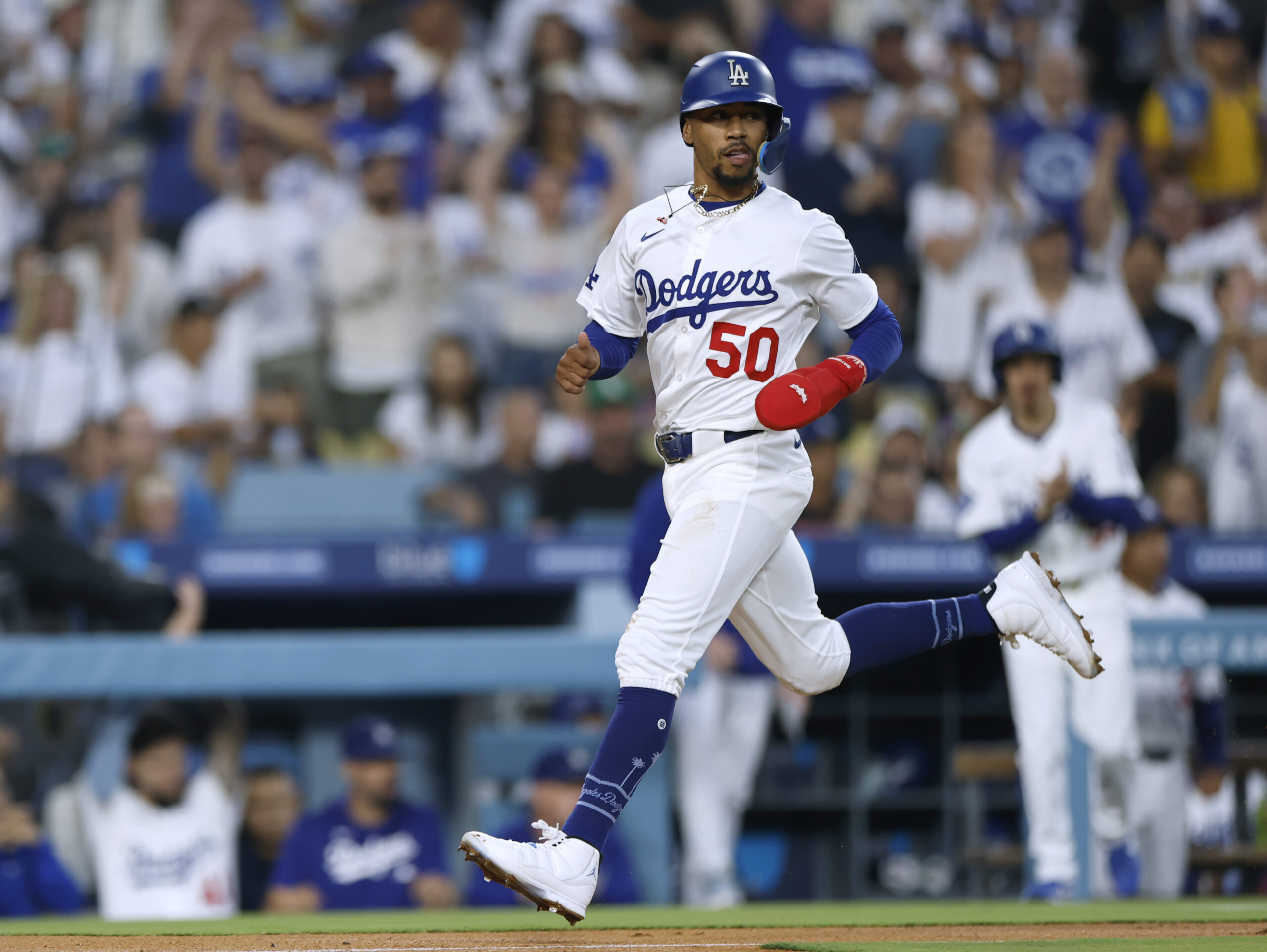 The Dodgers’ Mookie Betts runs home to score the tying...