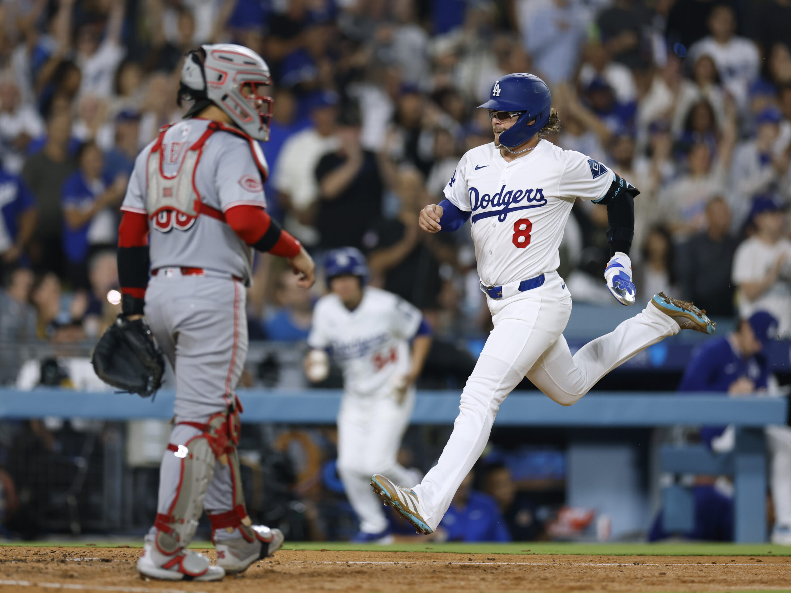 The Dodgers’ Kike Hernandez scores in front of Cincinnati Reds...
