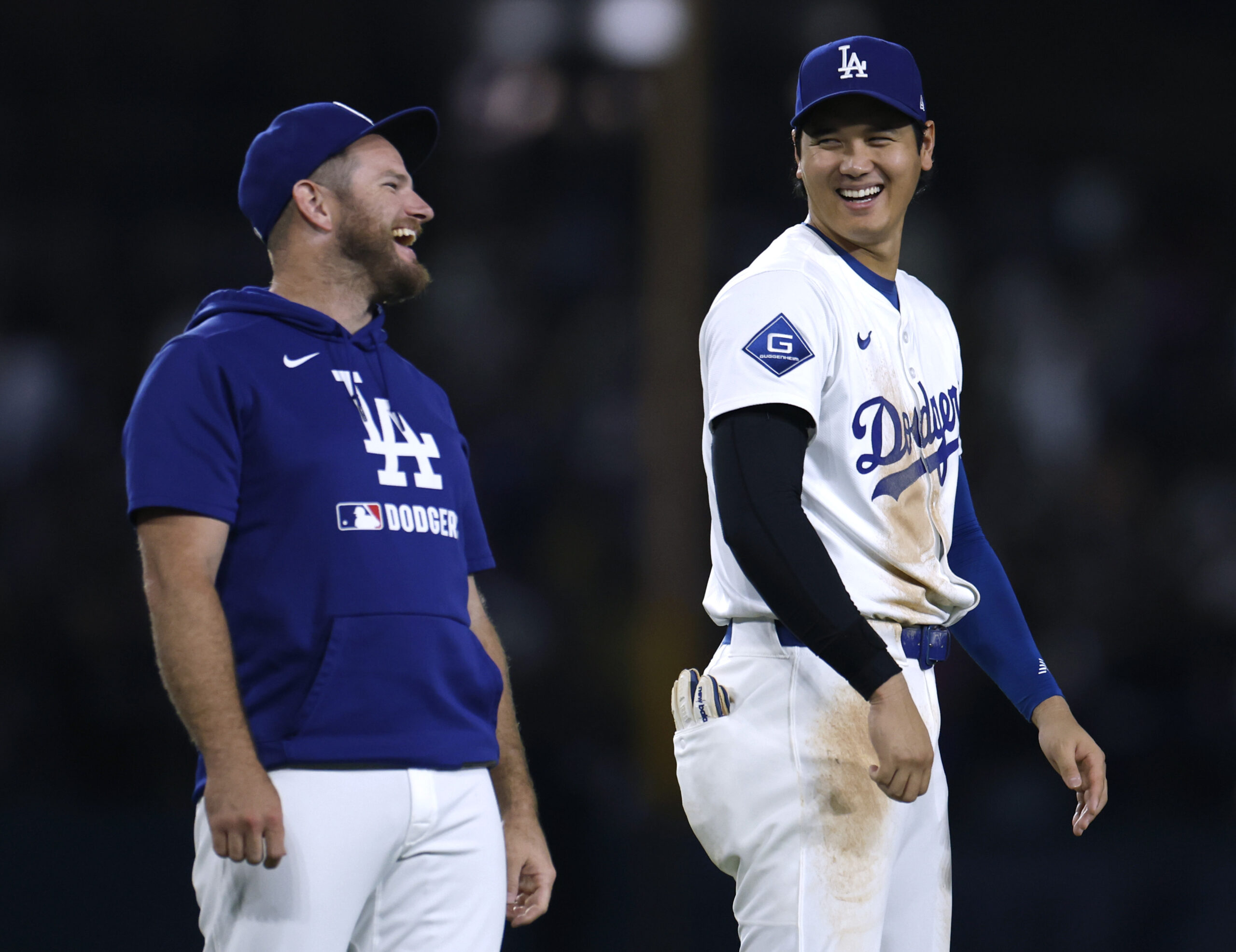 Dodgers teammates Shohei Ohtani, right, and Max Muncy laugh after...