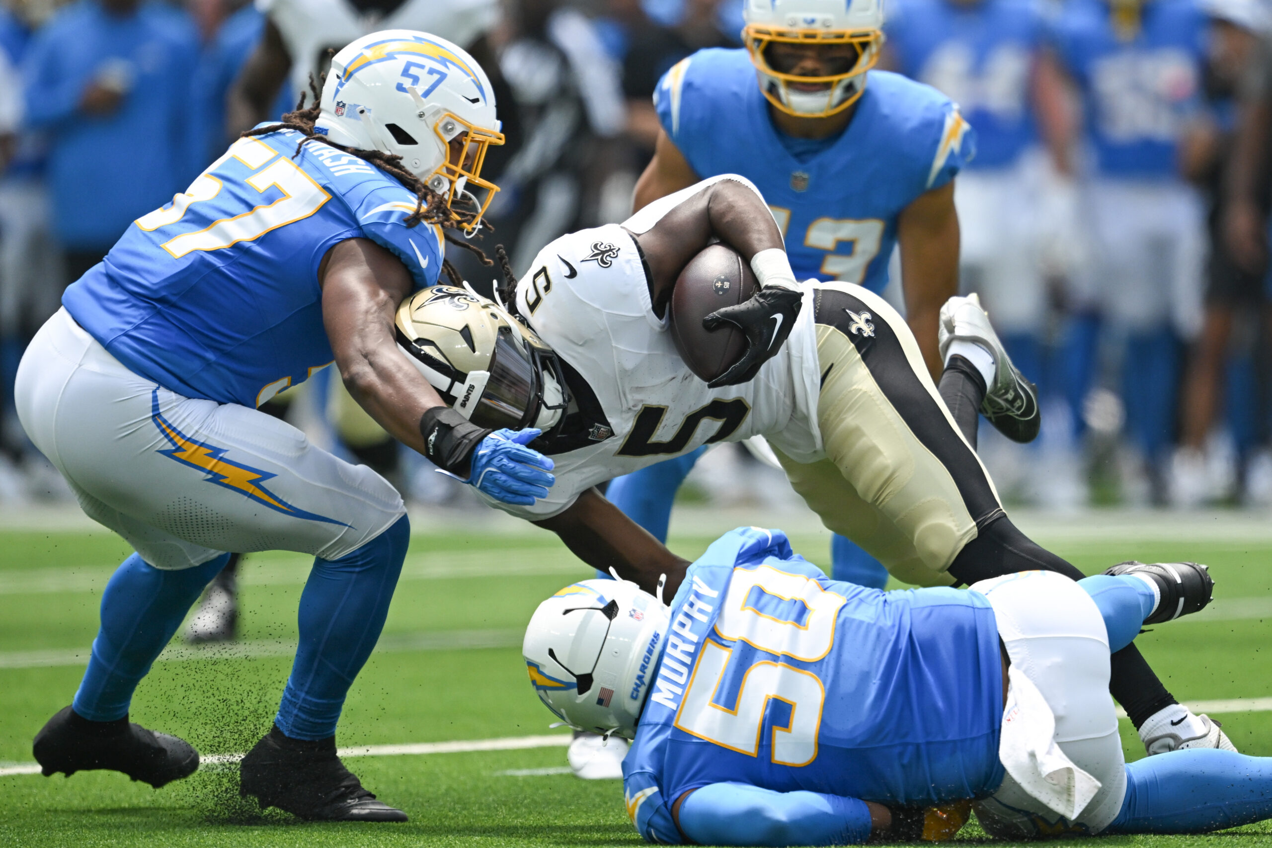 The Saints Kendre Miller, #5, drives for yardage as Chargers...