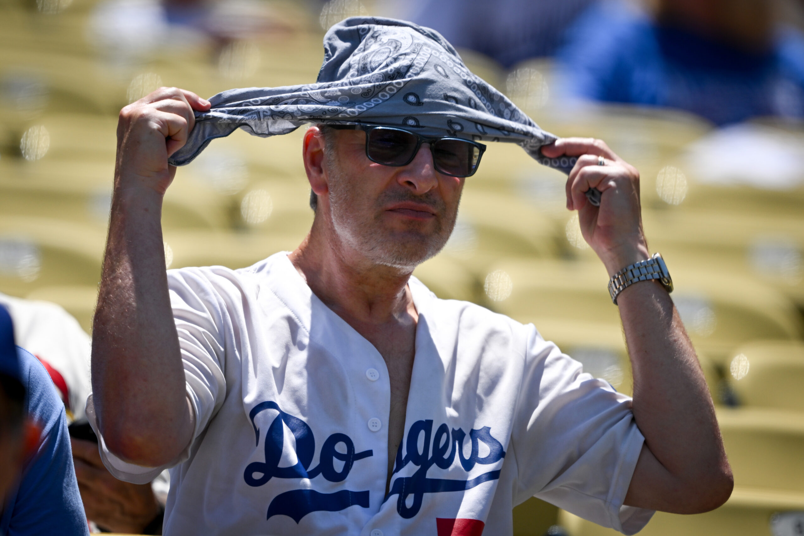 Fans make shade during a sweltering afternoon game at Dodger...