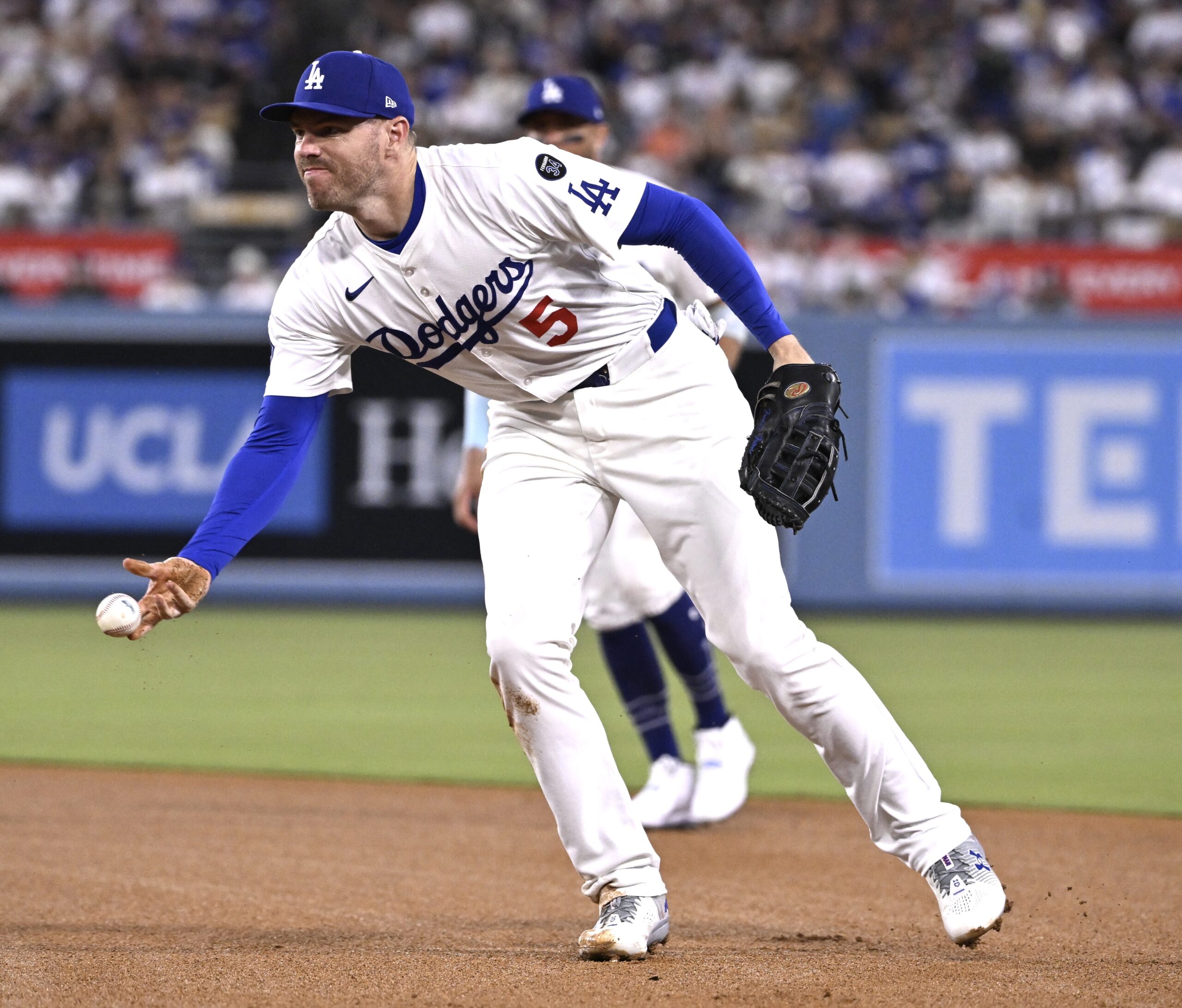 Dodgers first baseman Freddie Freeman tosses the ball to pitcher...
