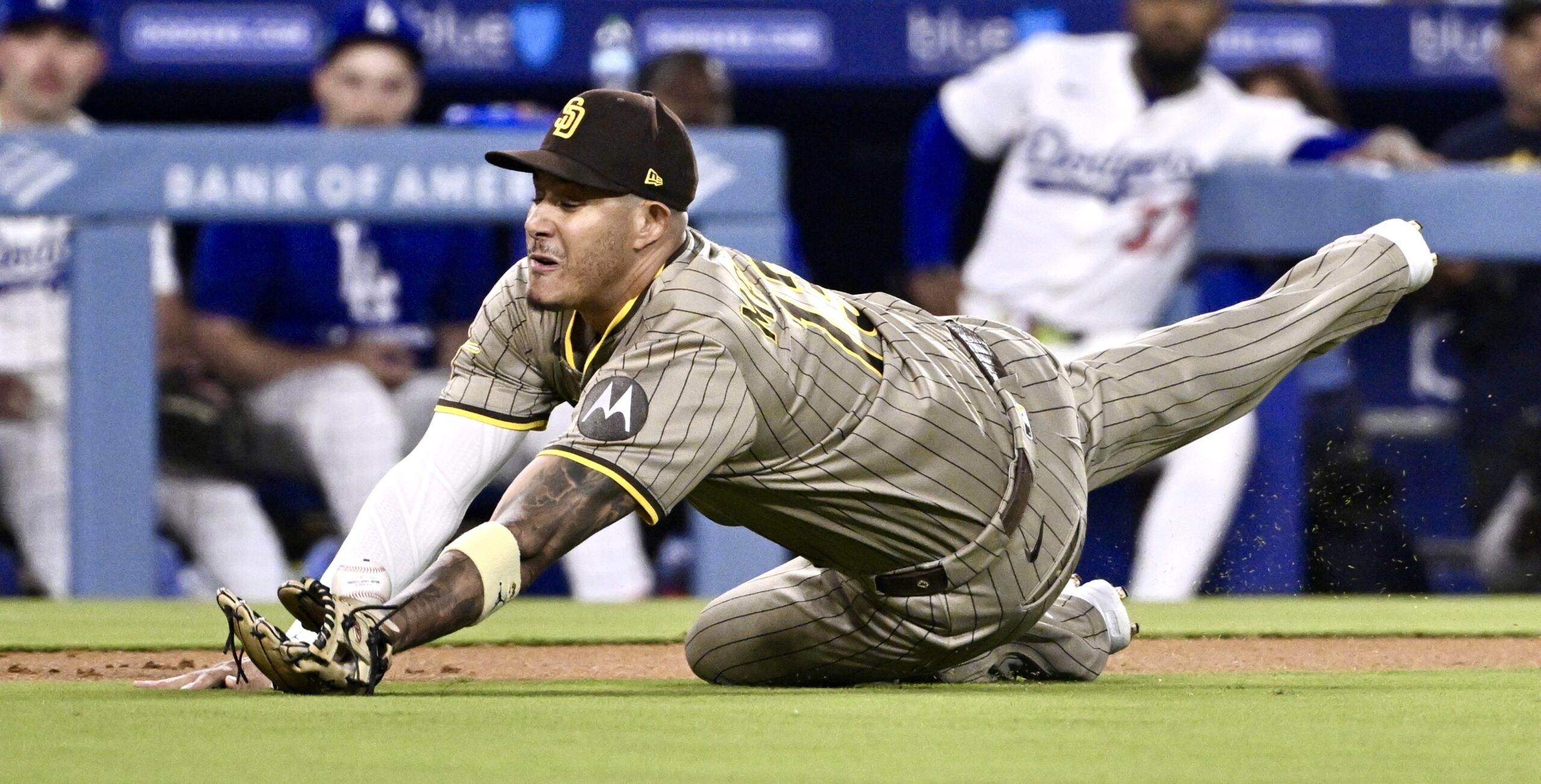 San Diego Padres third baseman Manny Machado dives to try...