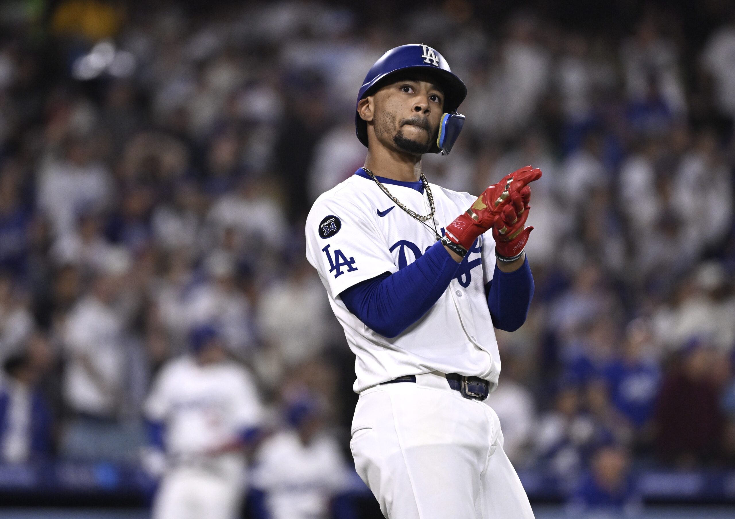 The Dodgers’ Mookie Betts claps after hitting a sacrifice fly...